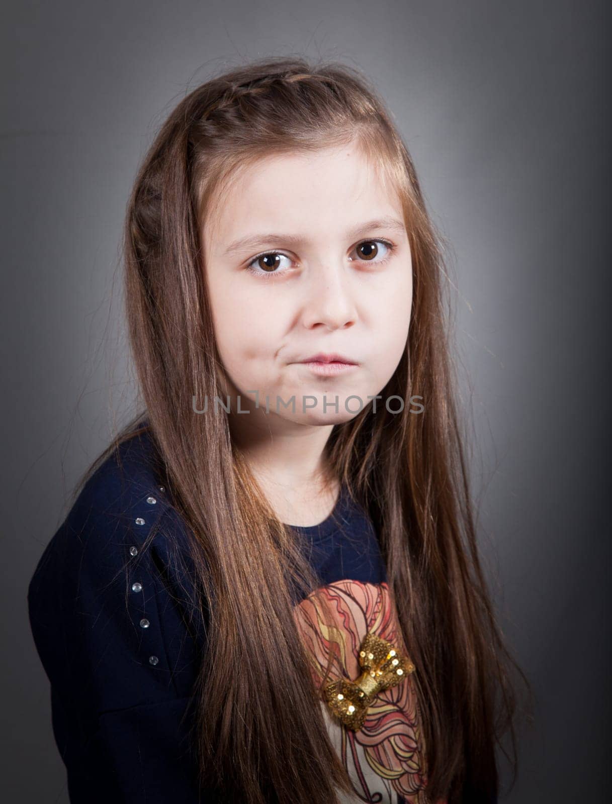 Portrait of a 8 year old girl, nicely dressed, studio shot.