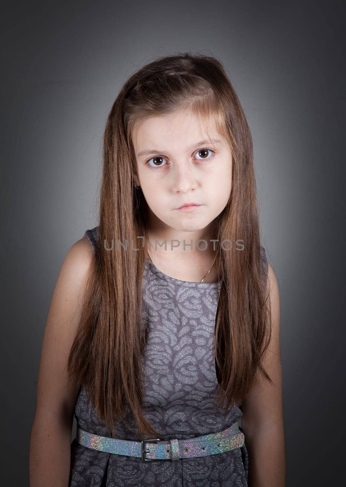 Portrait of a 8 year old girl, nicely dressed, studio shot.