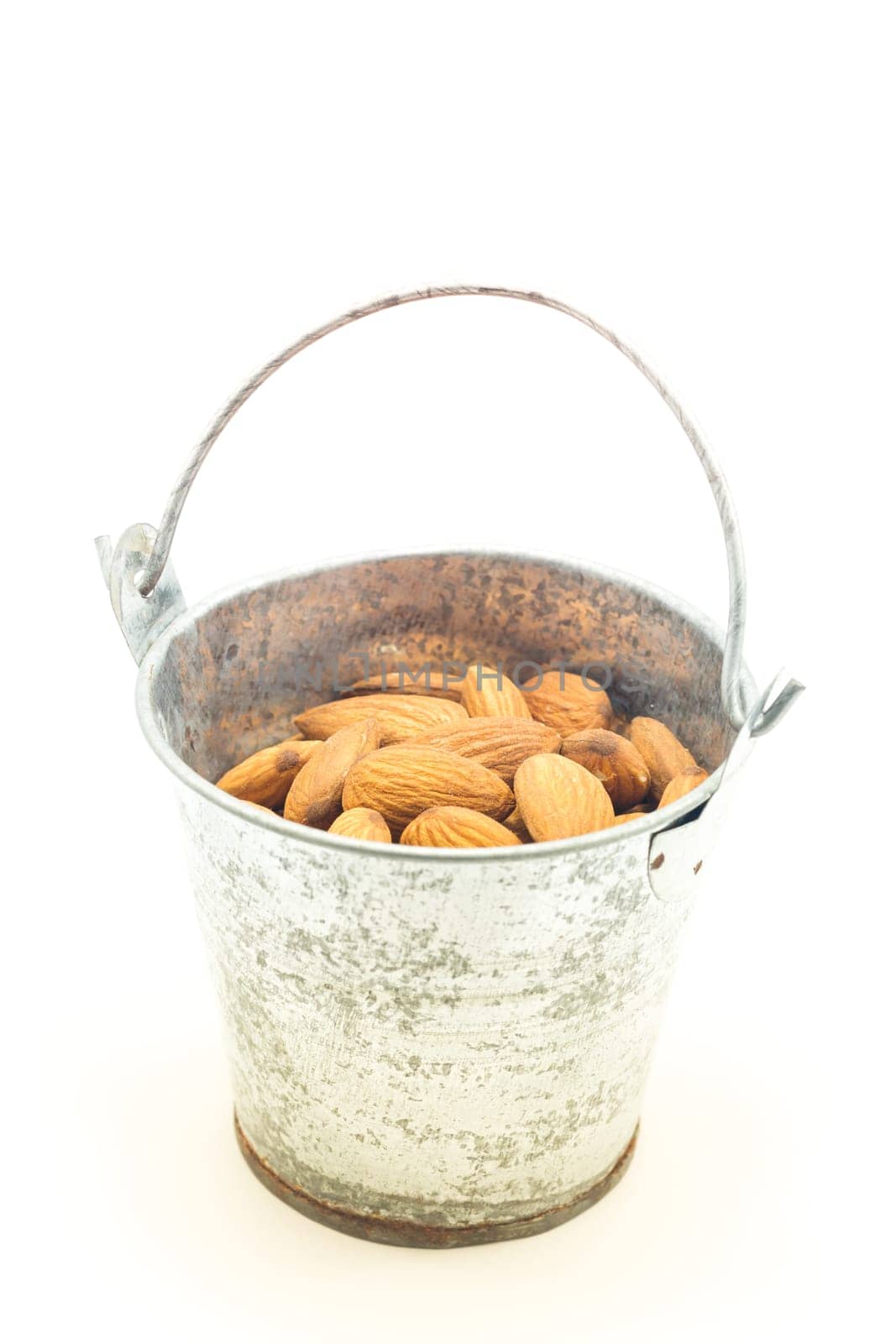 Almonds in bucket isolated on white background, stock photo