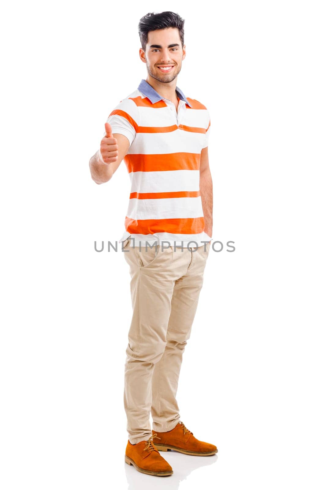 Portrait of handsome young man with thumbs up, isolated over a gray background