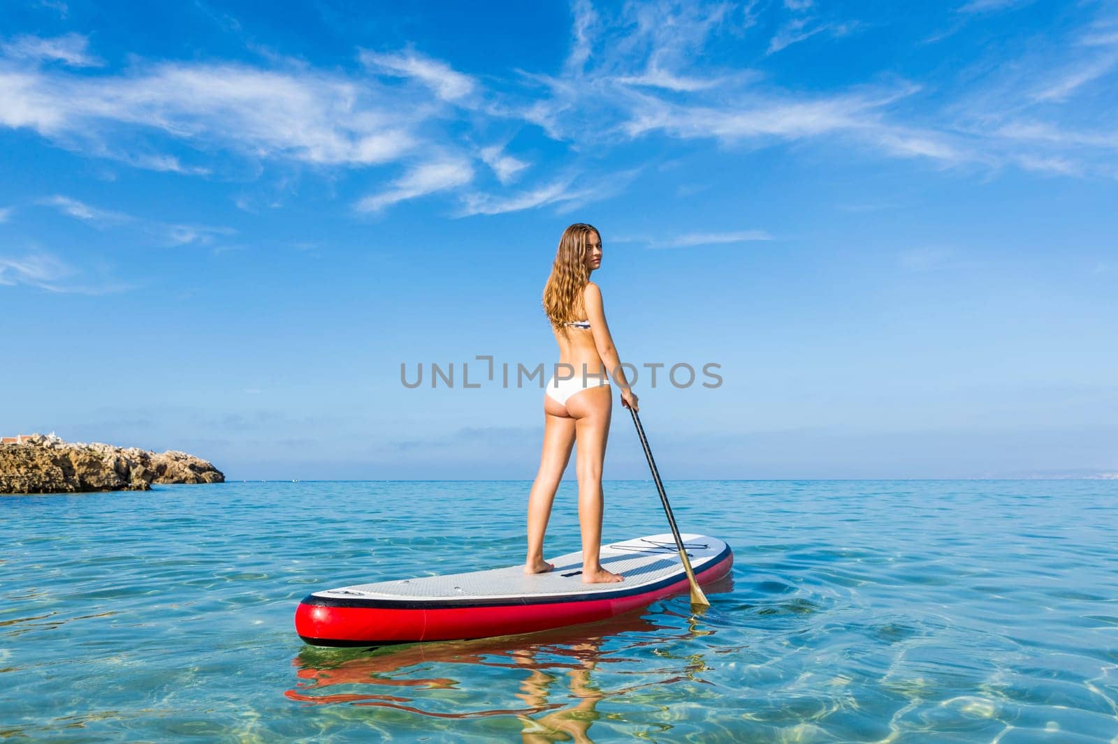 A beautiful woman practicing paddle on a beautiful sunny day