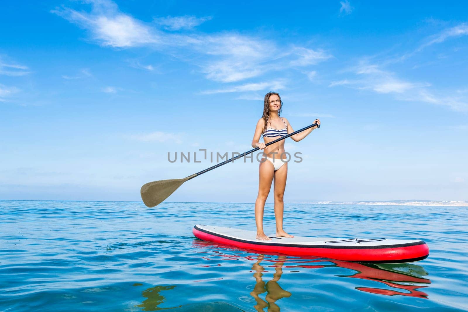 A beautiful woman practicing paddle on a beautiful sunny day