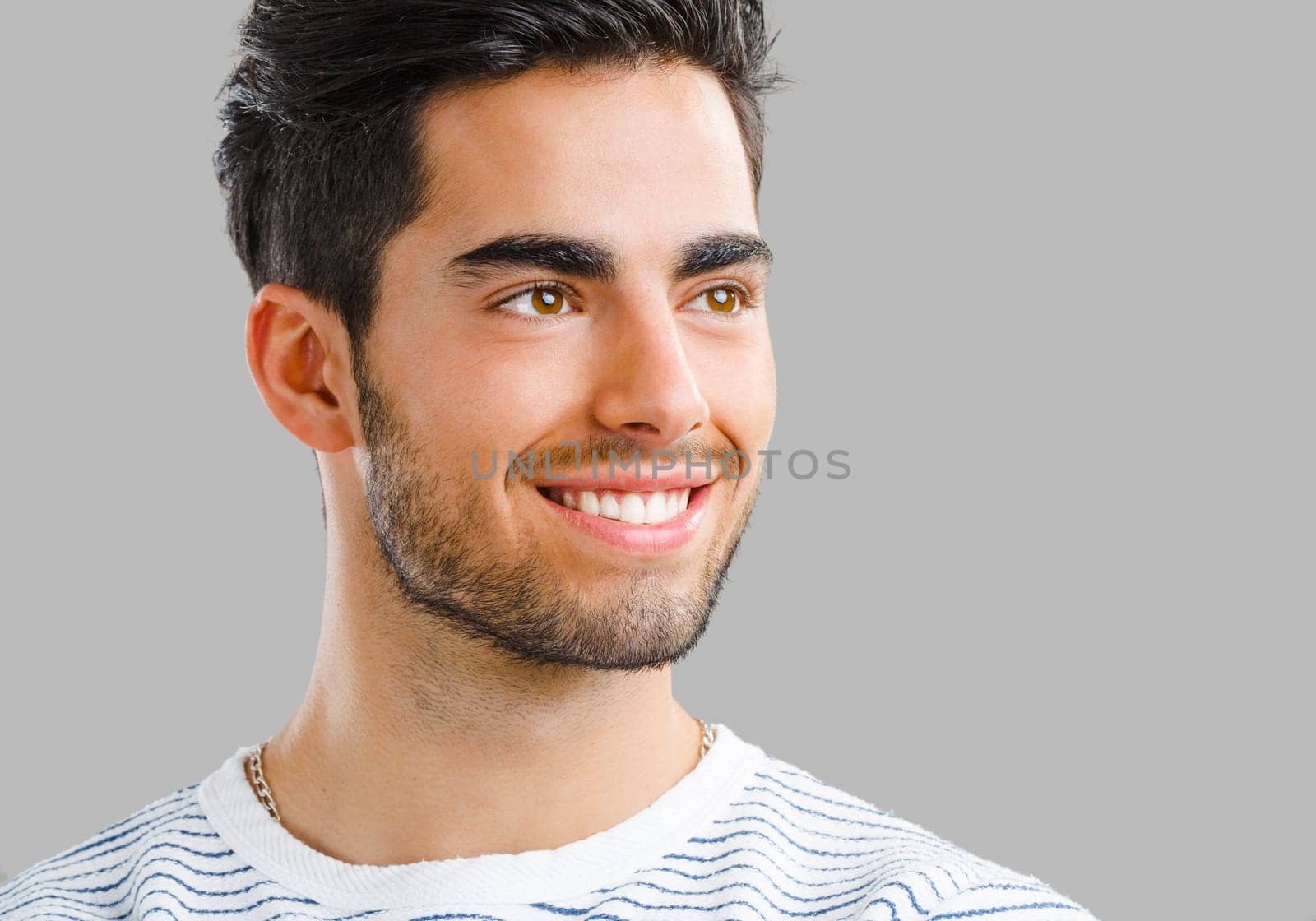 Portrait of handsome young man smiling, isolated on gray background