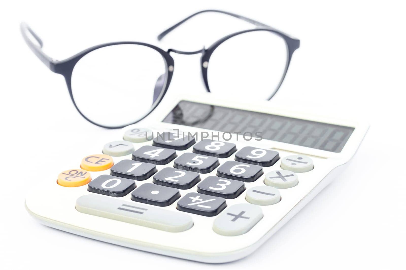 Calculator with eyeglasses isolated on white background, stock photo