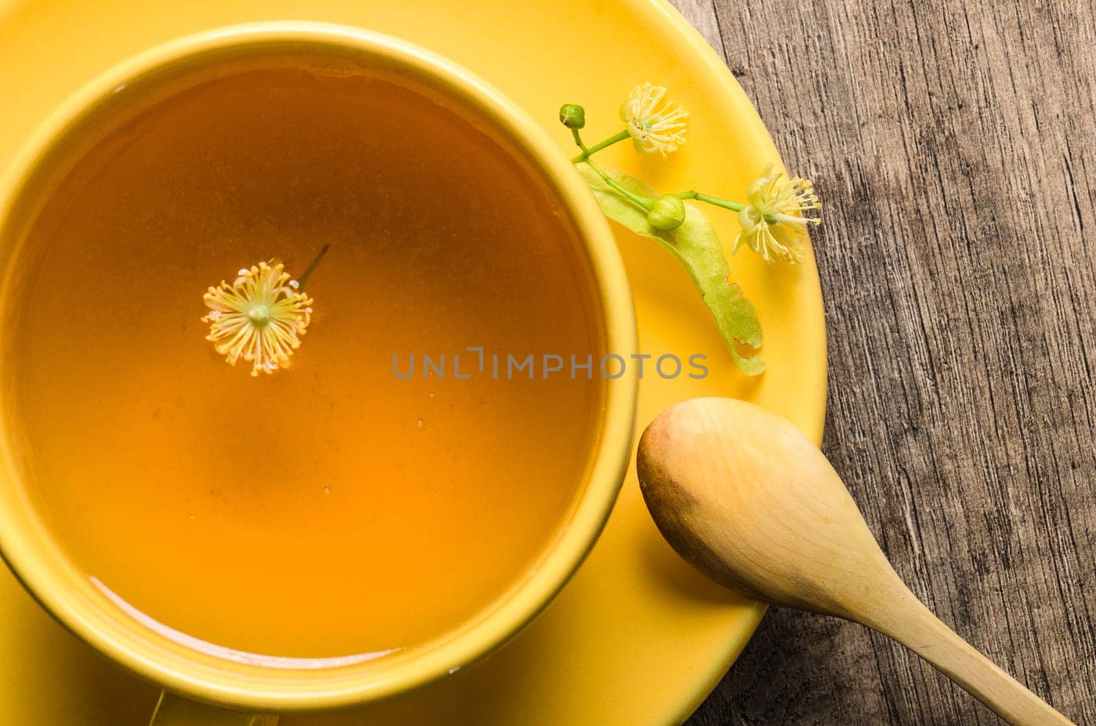 Yellow cup with linden tea on the table,  top view