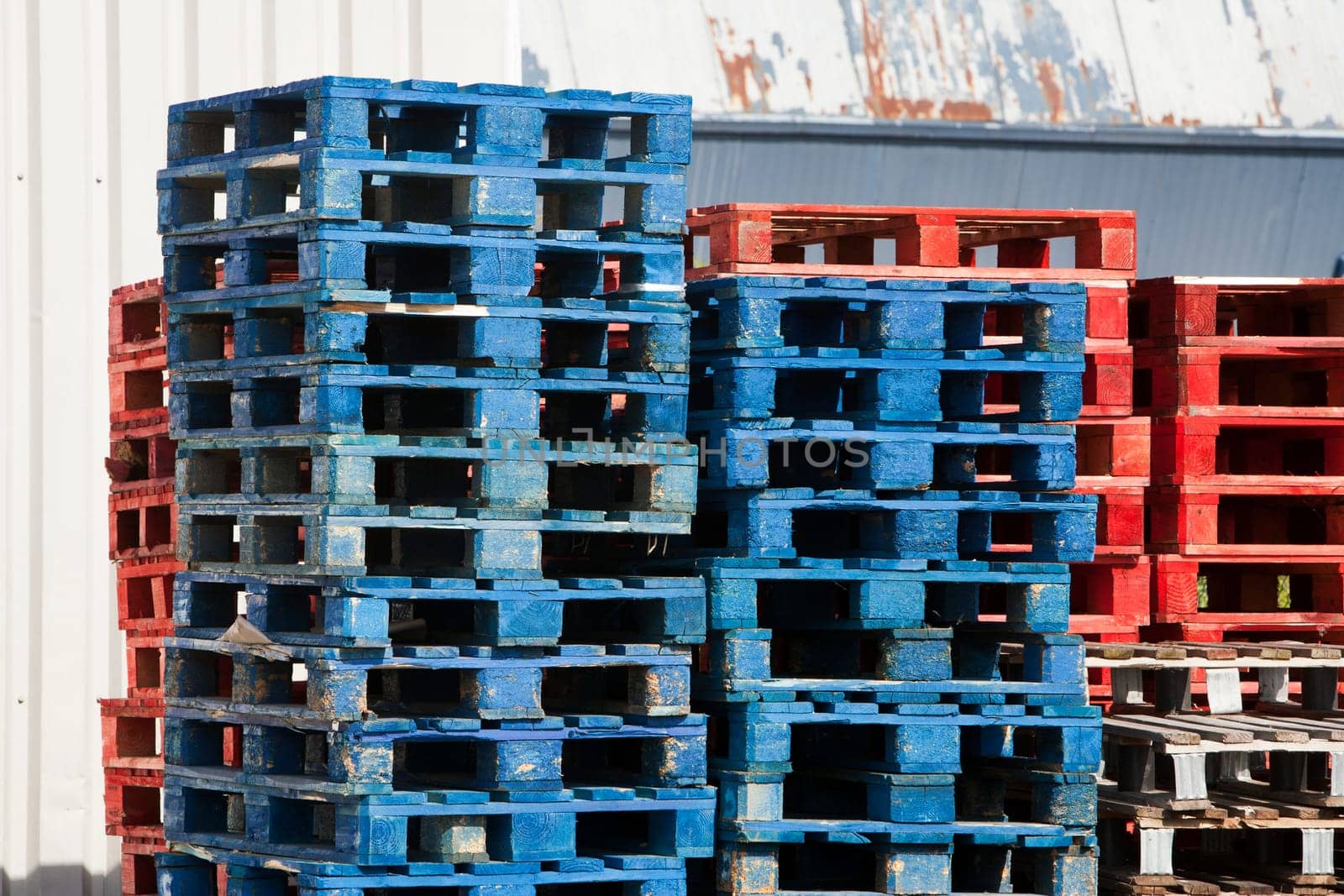 A stack of blue and red wooden pallets