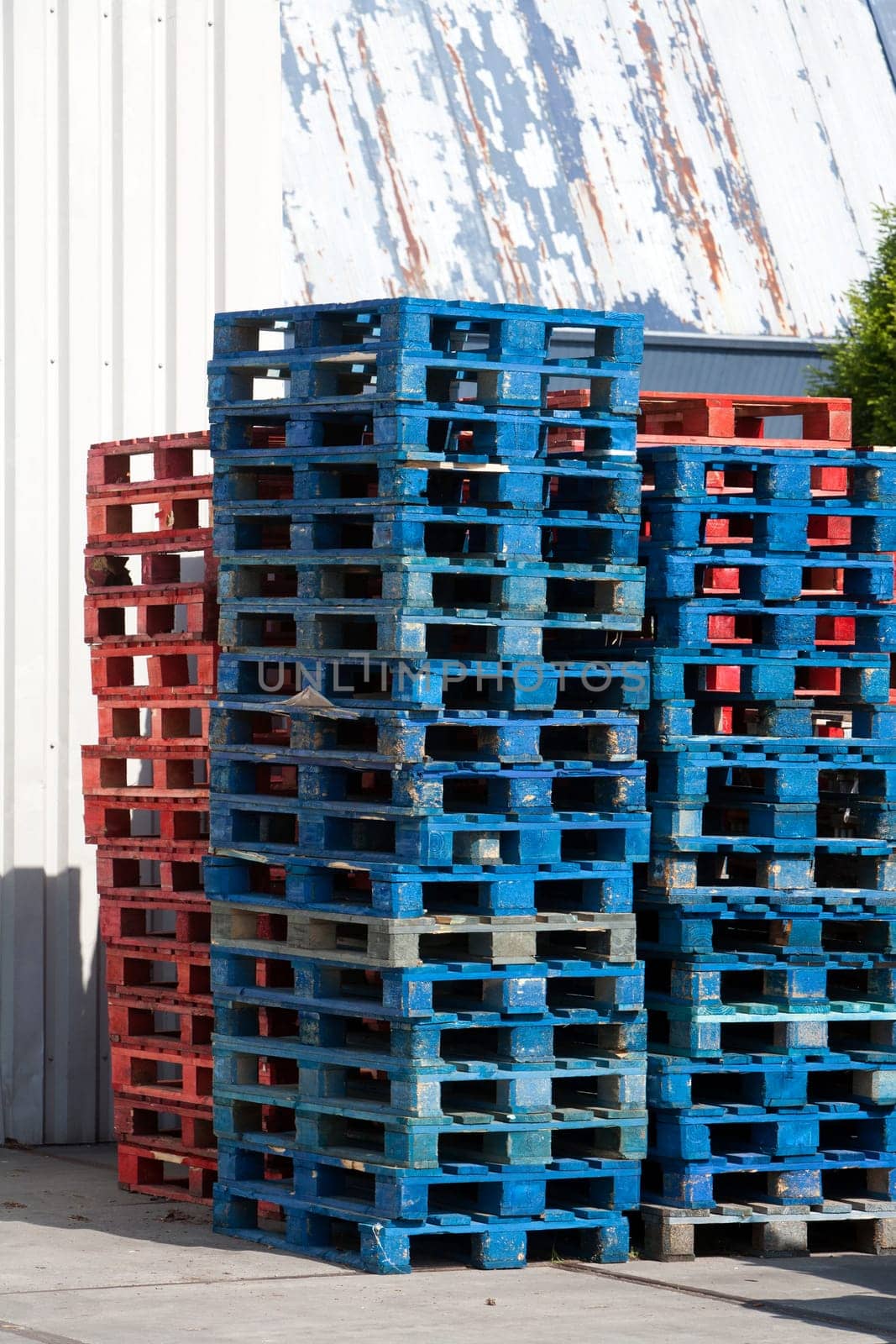 A stack of blue and red wooden pallets