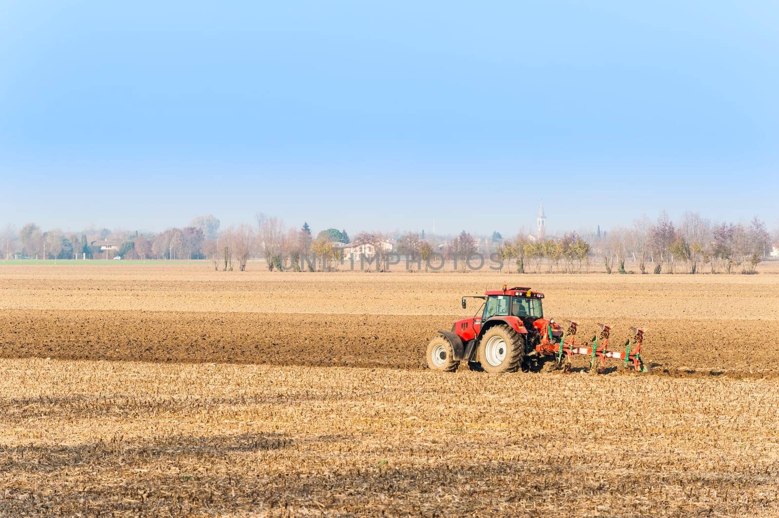 Agricultural labor, Red Tractor plowing a field