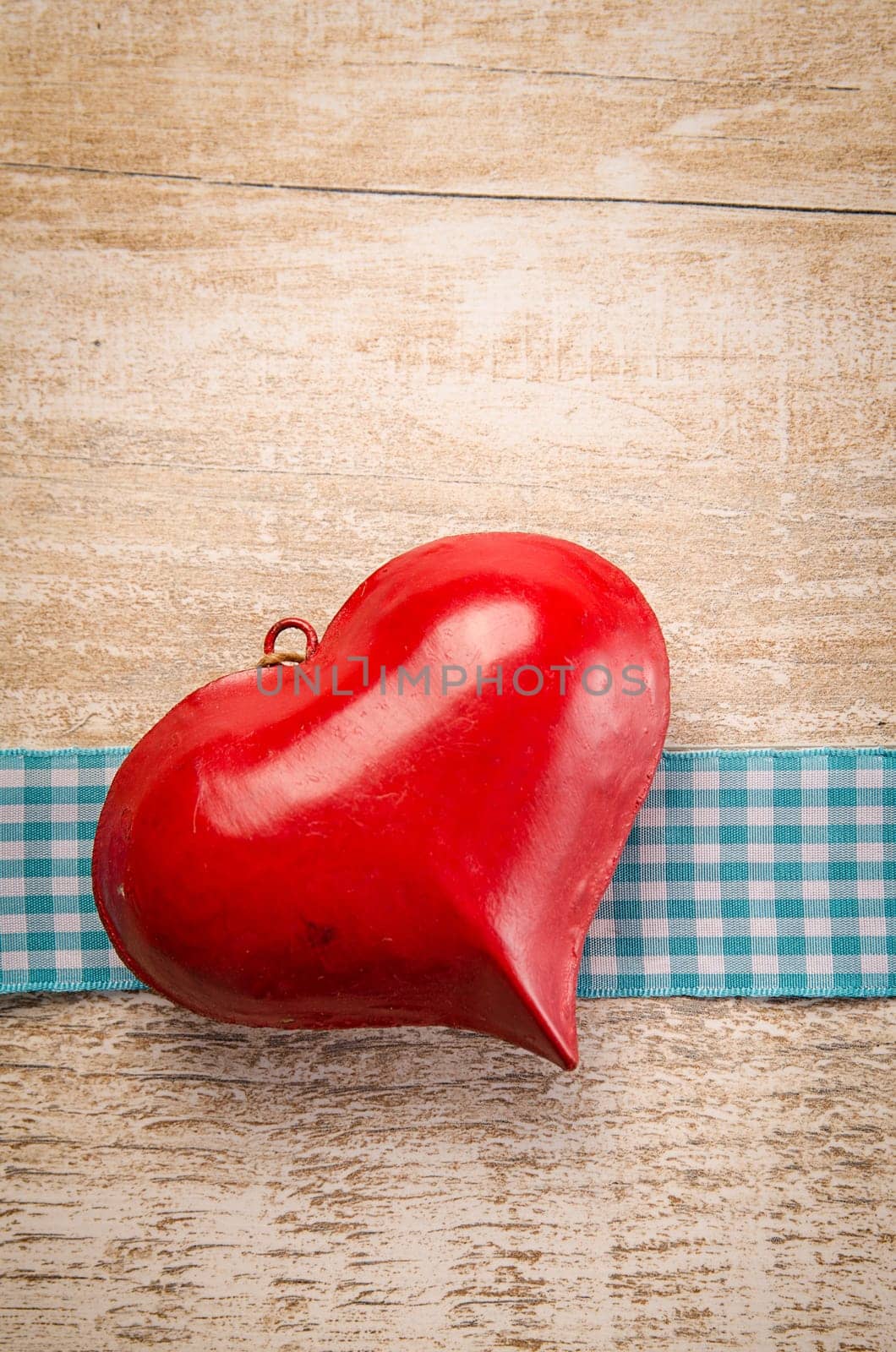 Red old heart shape on a rustic wooden table with space for text or image