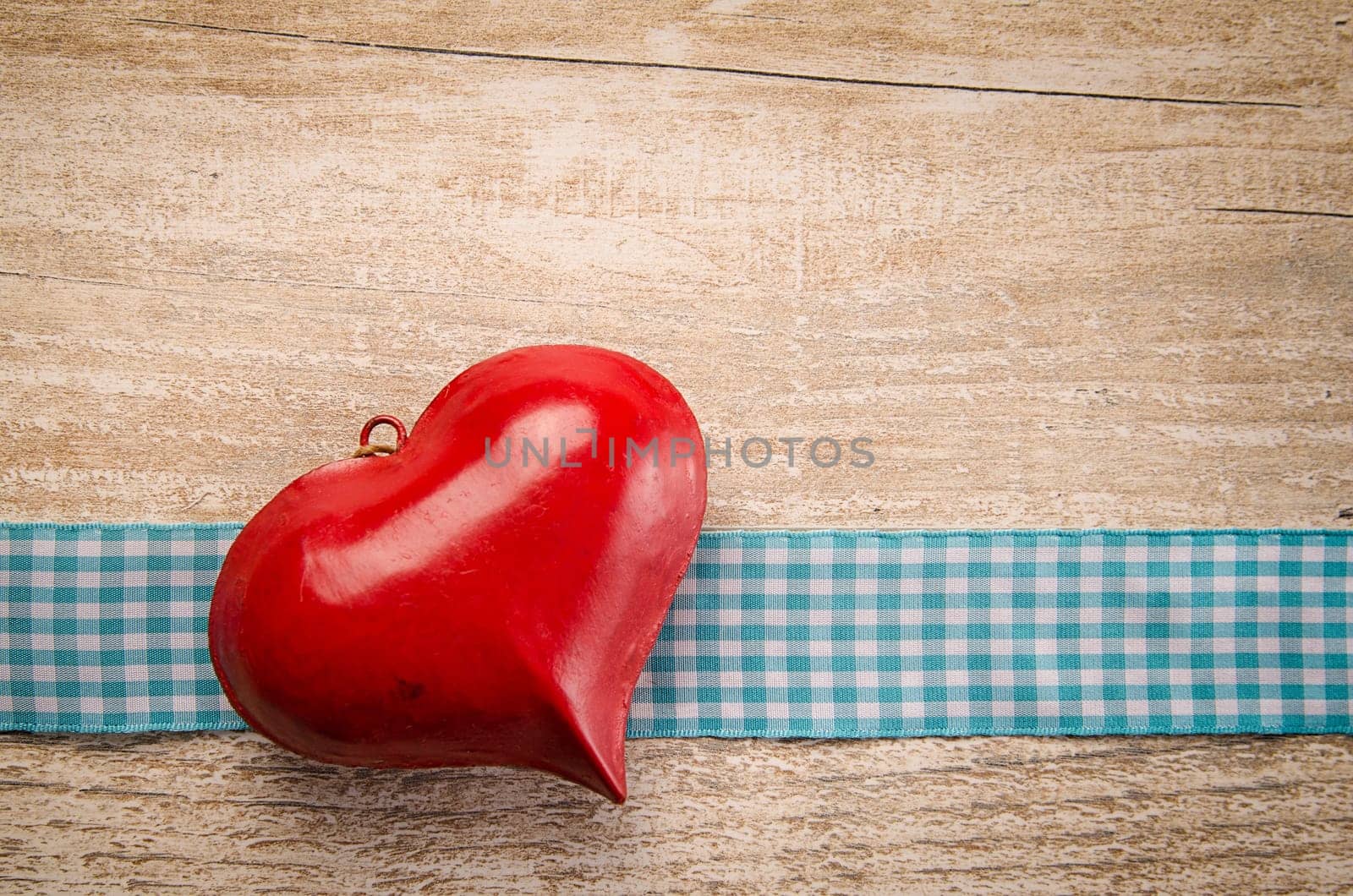 Red old heart shape on a rustic wooden table with space for text or image
