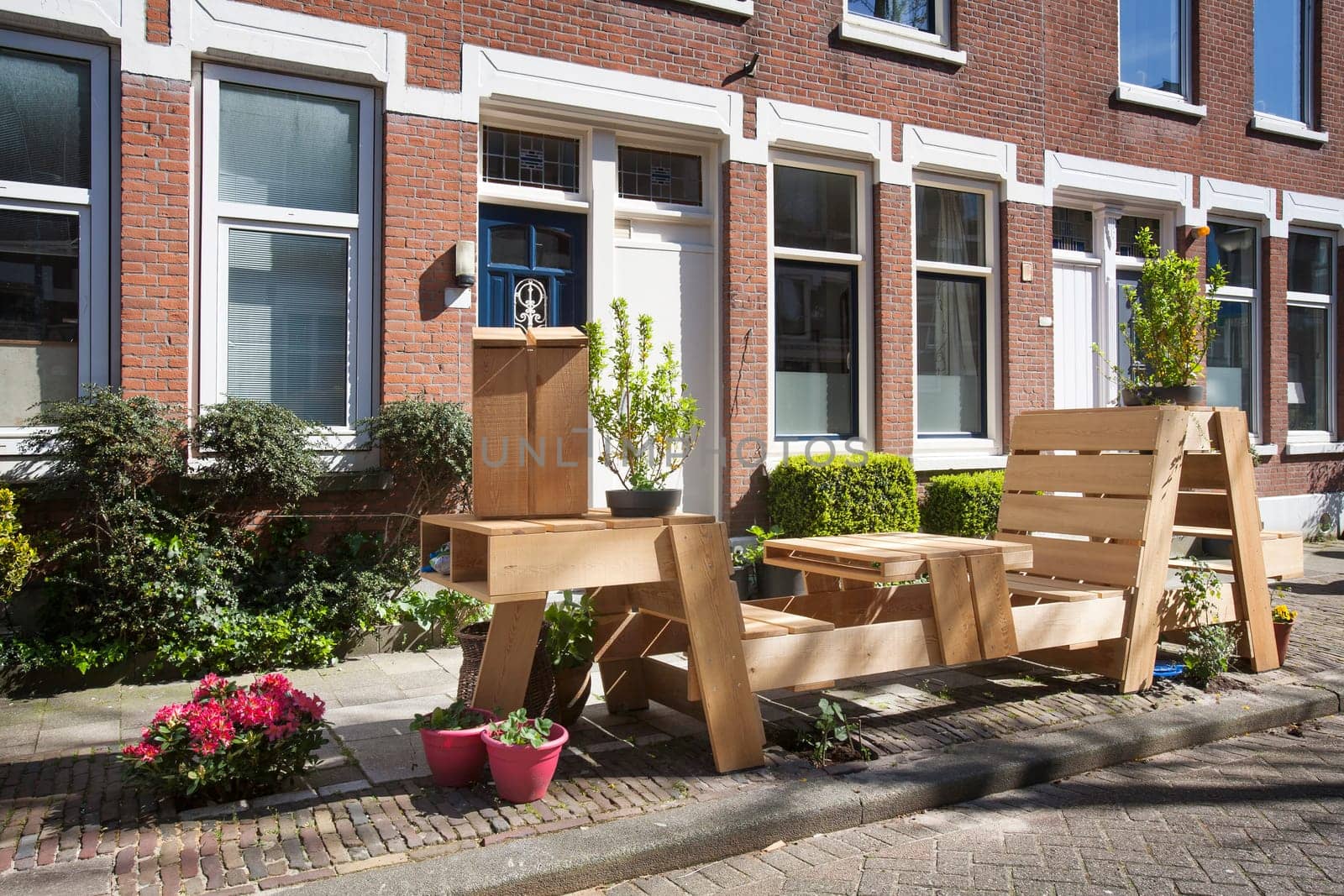 Wooden benches and flowers  in front of the front door in this street in the residential district Kralingen in Rotterdam, the Netherlands.