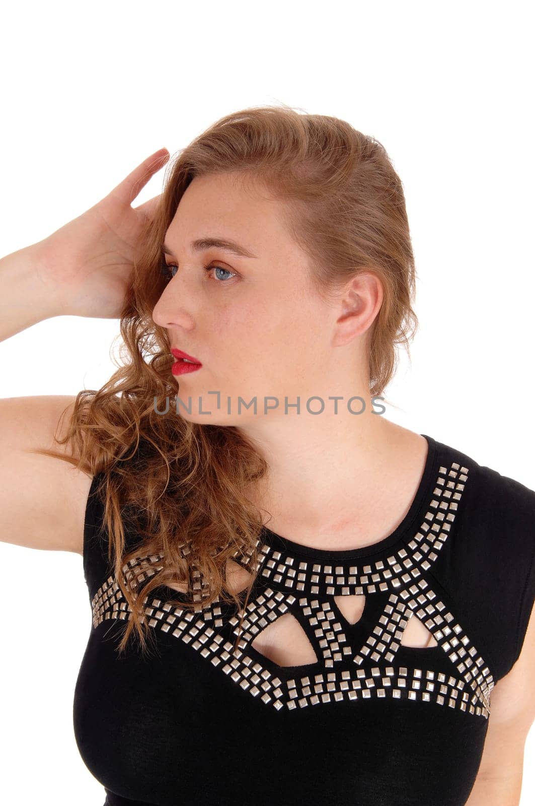A closeup image of a blond woman in a black dress with silver trimmings.holding one hand behind her head, isolated for white background..