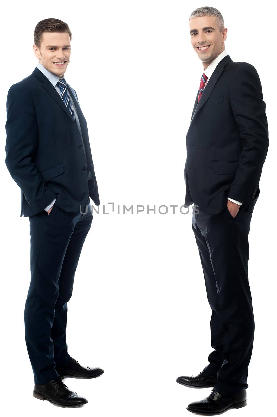 Young businessmen posing with hands in pockets