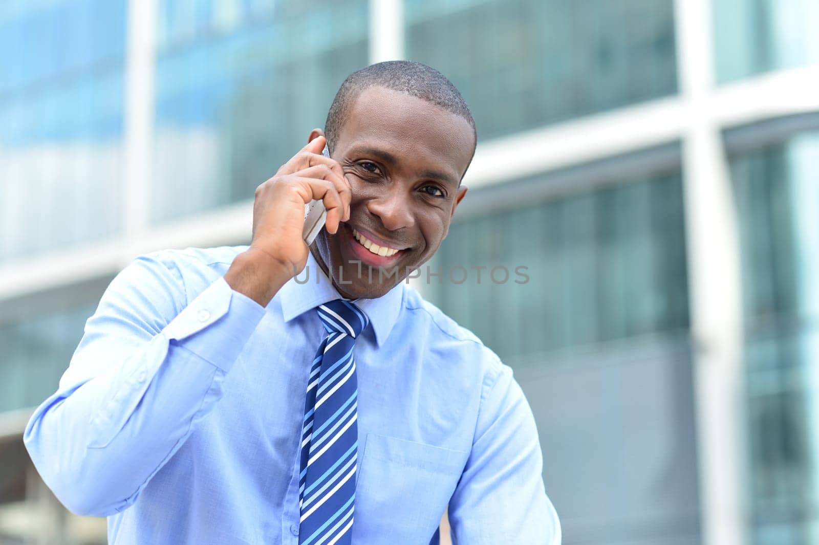 Happy male executive speaking using cell phone