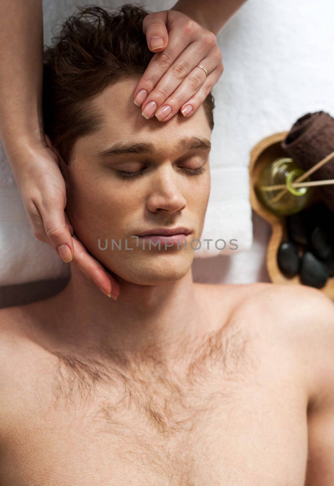 Relaxed man getting a face massage at day spa