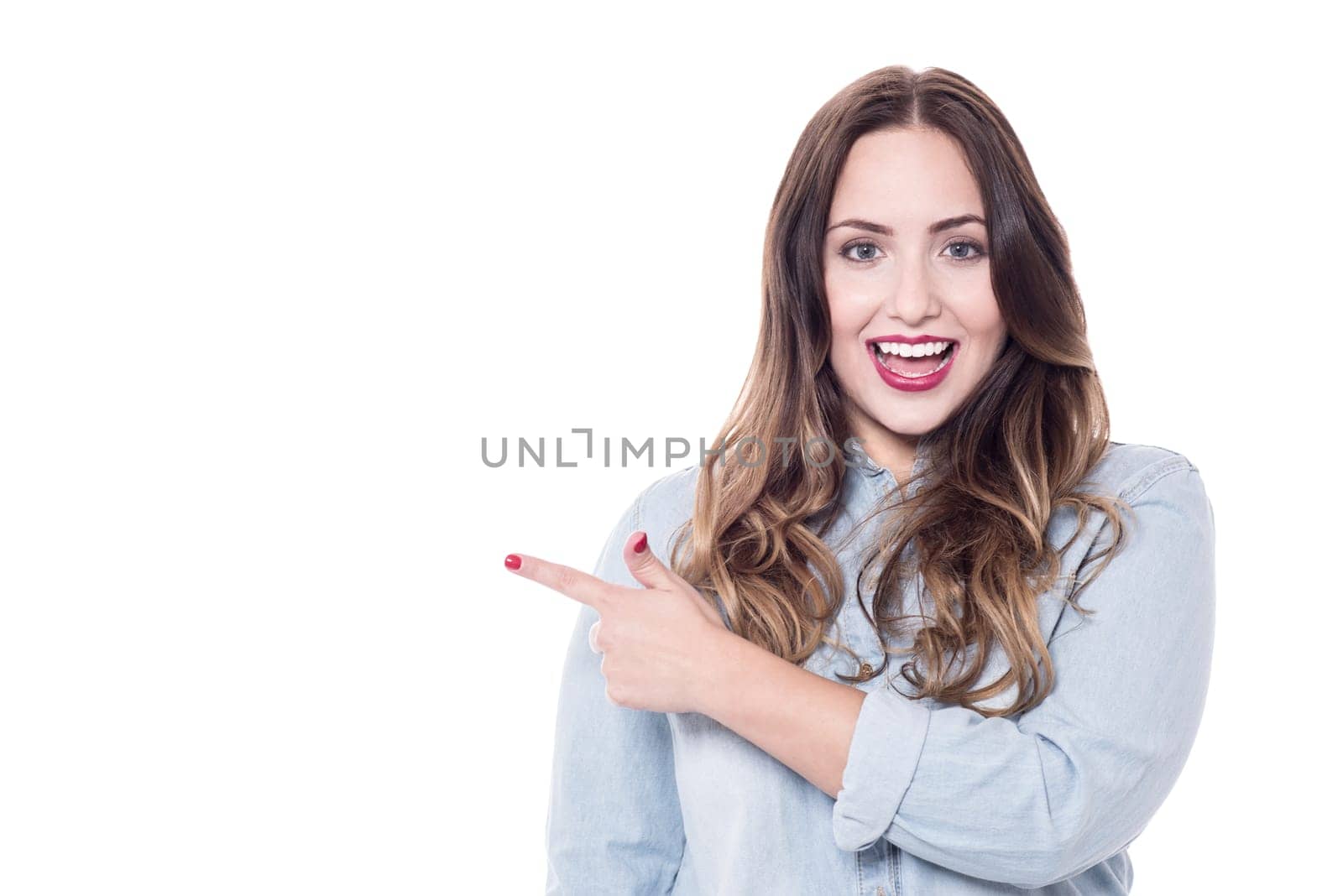 Happy woman pointing at copy space over white