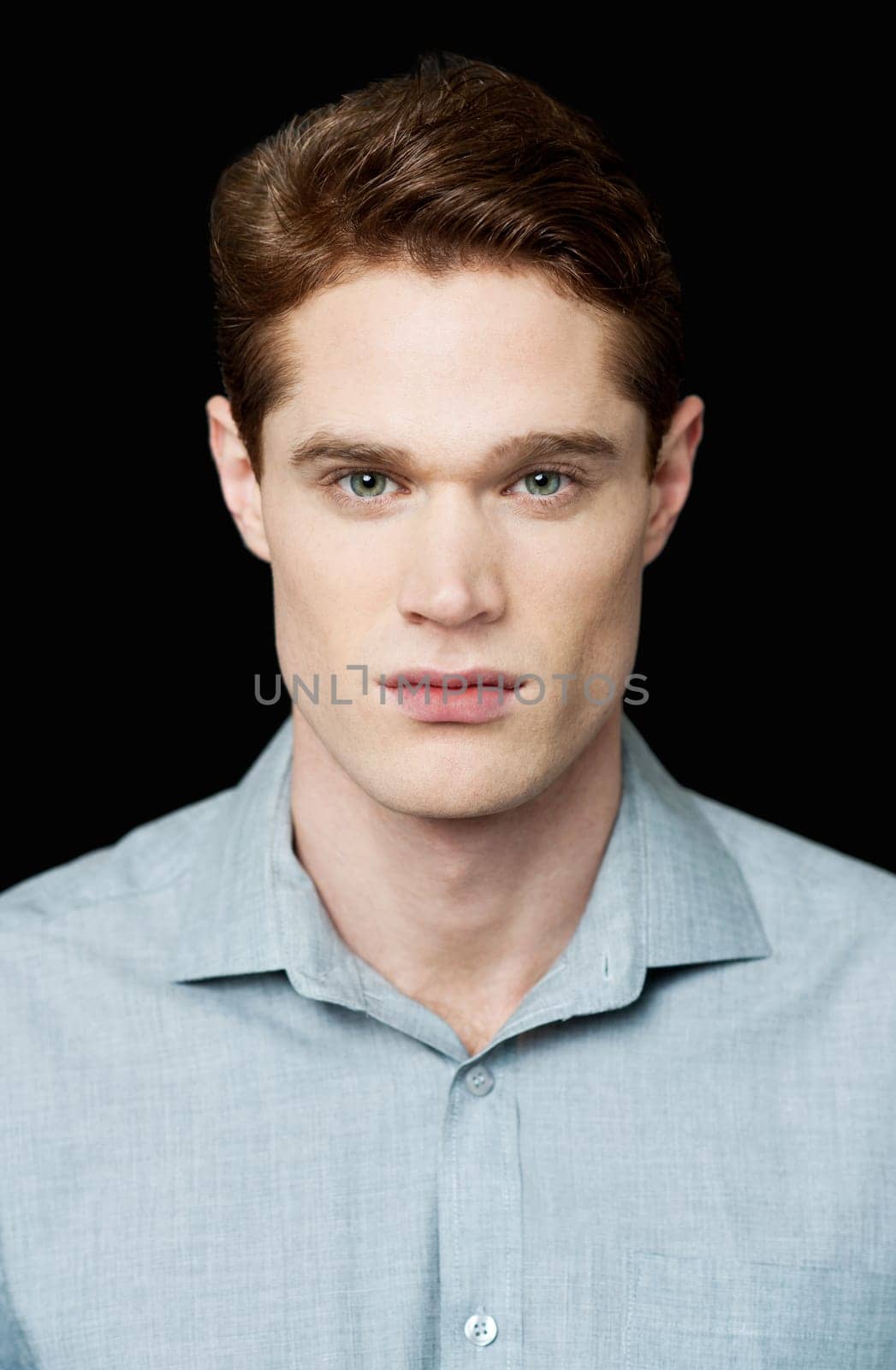 Handsome young man posing over black background