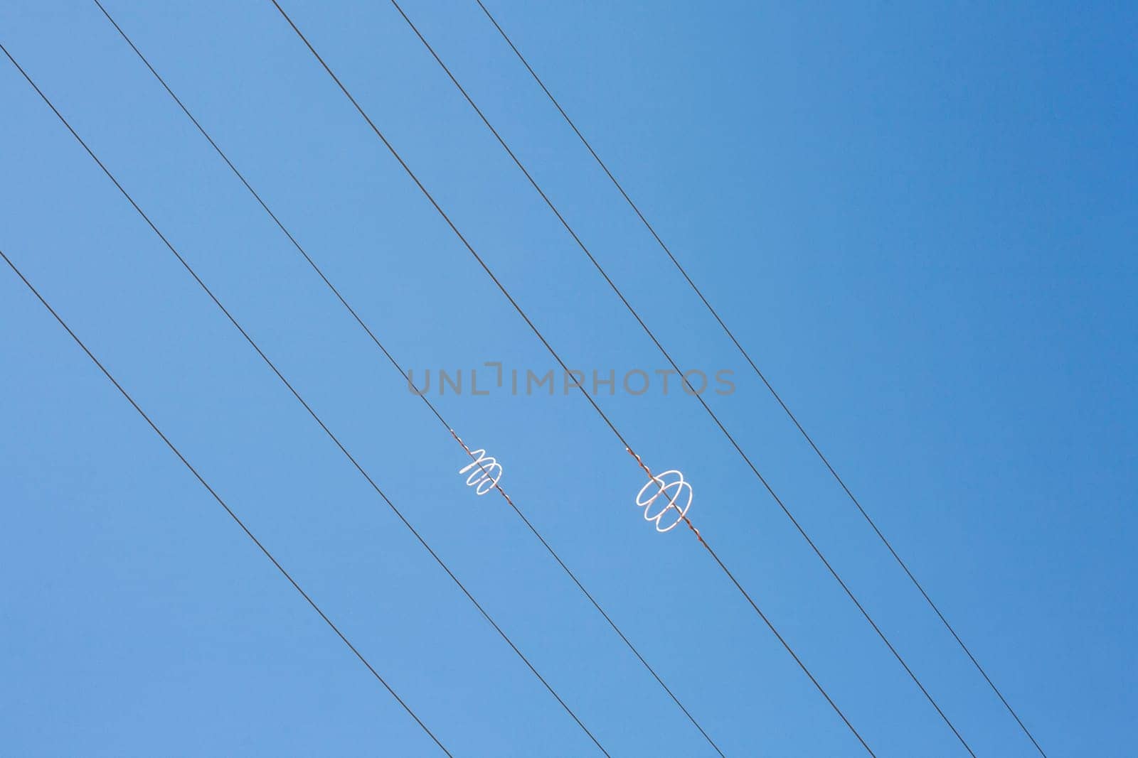 Power line wires over blue sky. Closeup