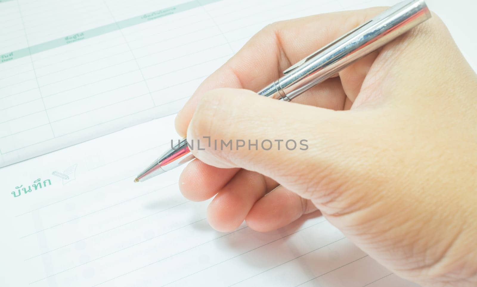 Hand on metallic pen write on the paper, stock photo