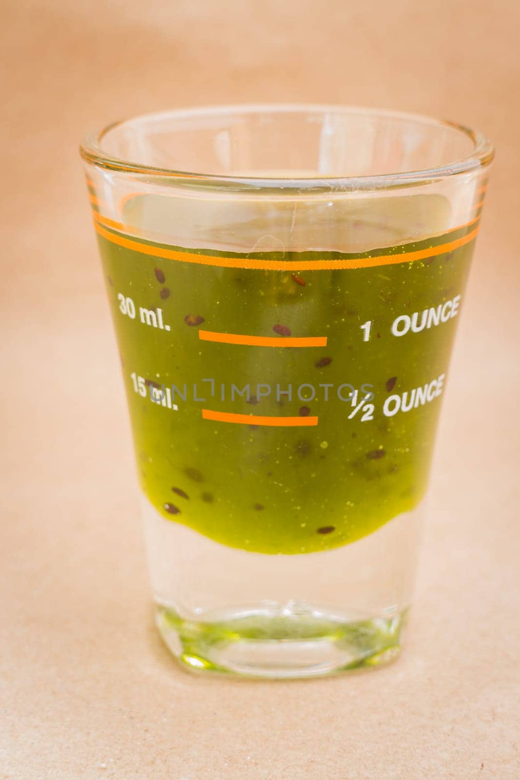 Glass shot of kiwi syrup, stock photo