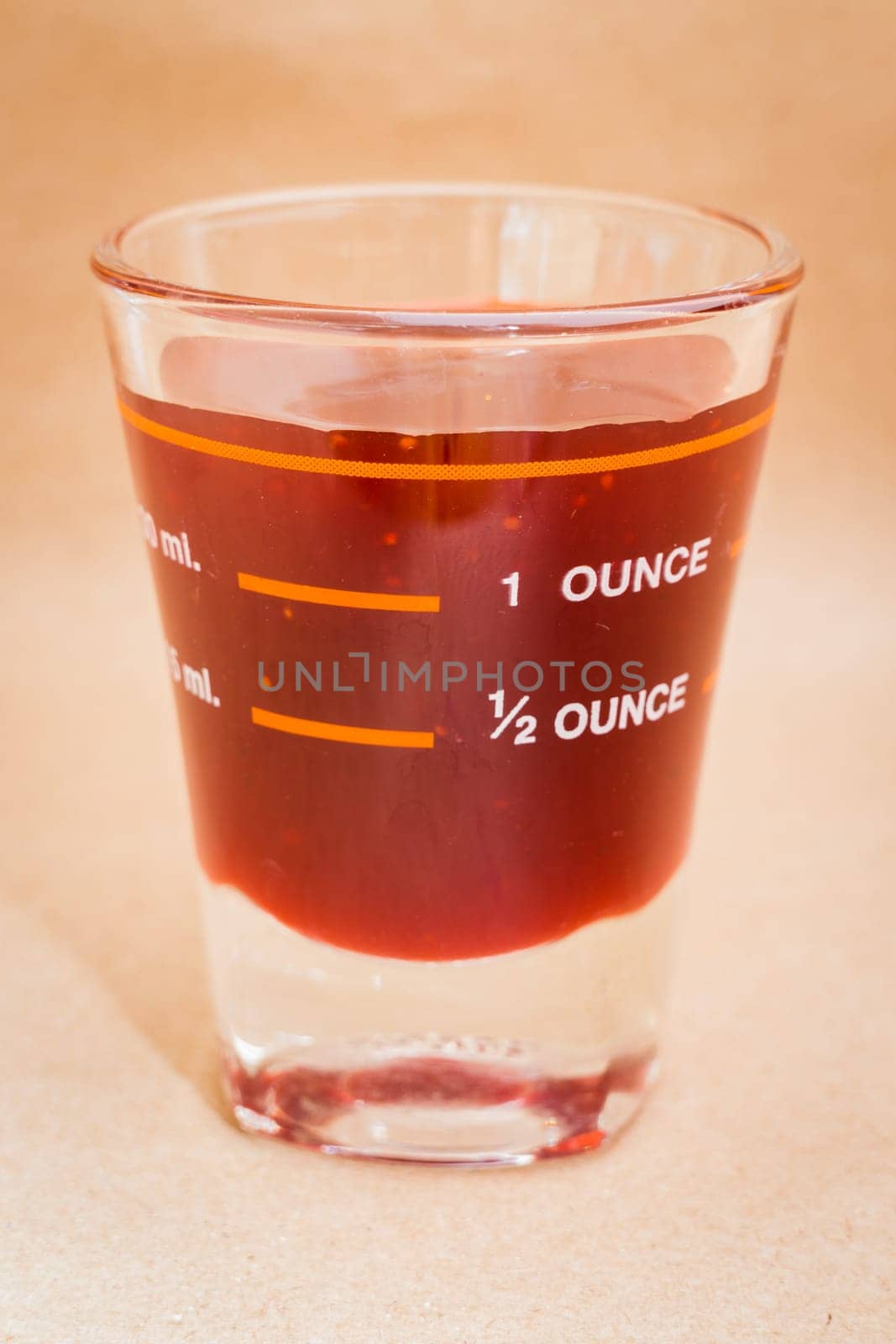 Glass shot of strawberry syrup, stock photo