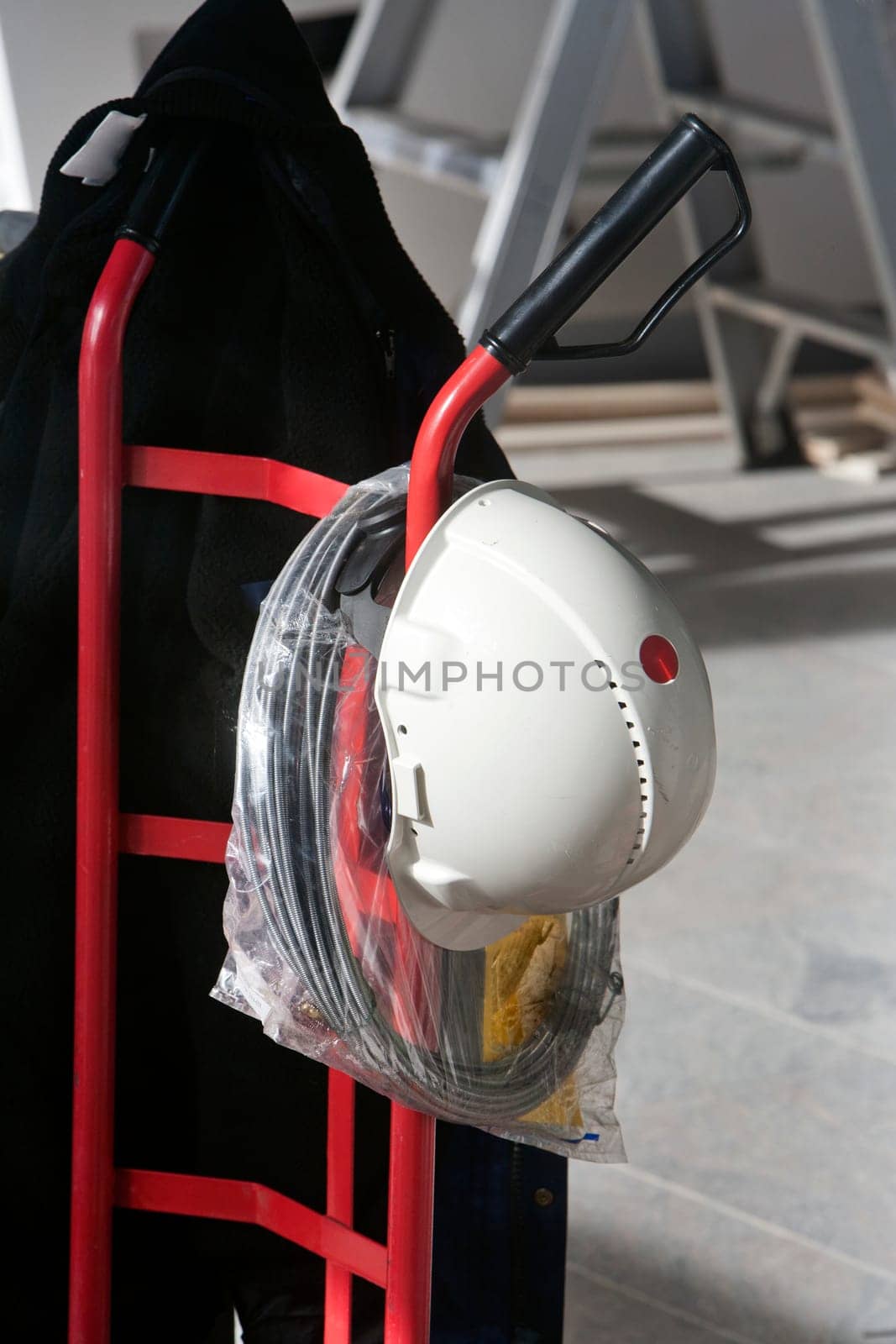 Red trolley used as a peg for hardhat and coat.