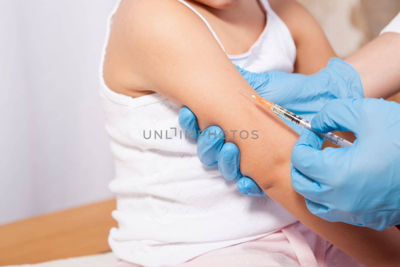 Doctor vaccinating a little girl. Isolated over white background