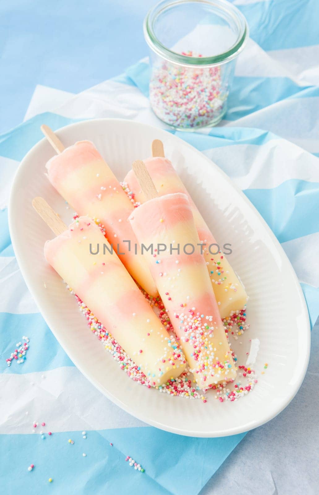 Striped ice cream on the stem with colorful sugar sprinkles