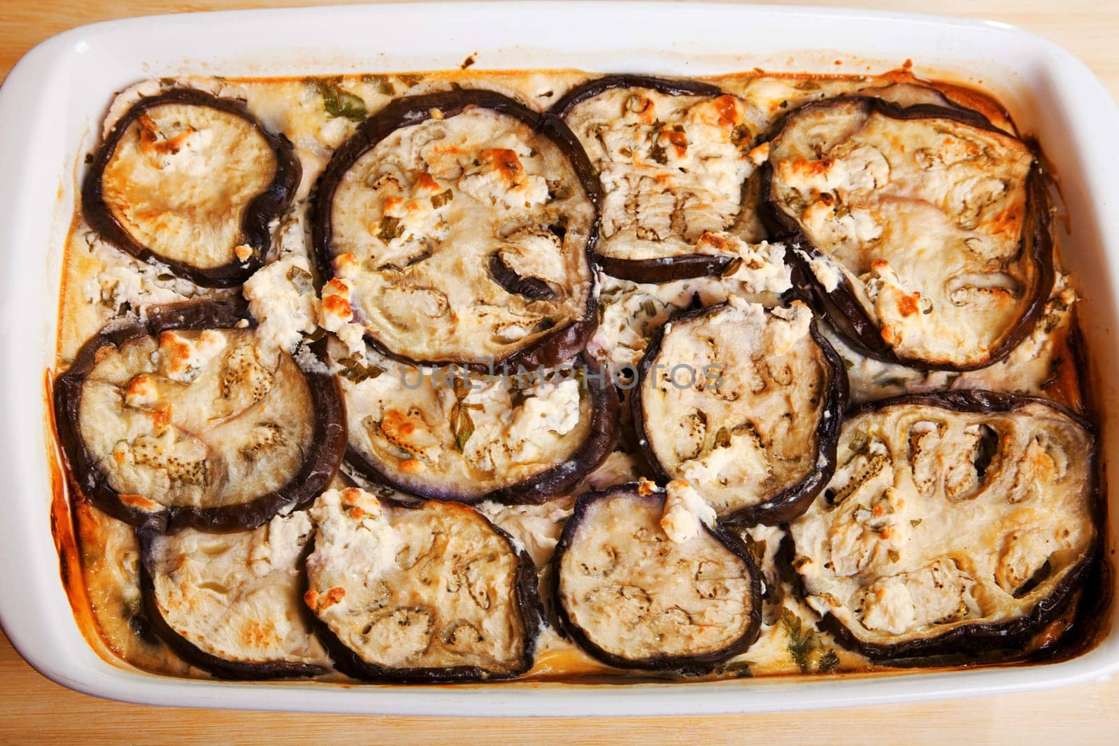 Baked eggplants with cheese and eggs, cooked main course meal in a baking dish