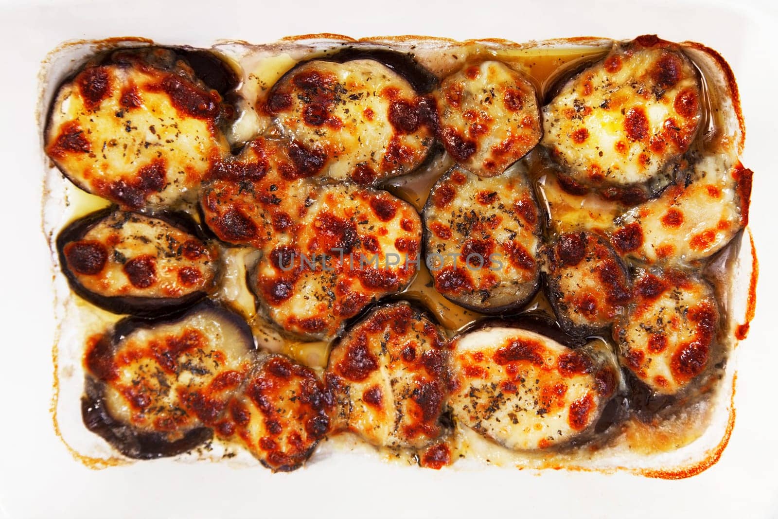 Baked eggplants with mozzarella and basil in a baking dish
