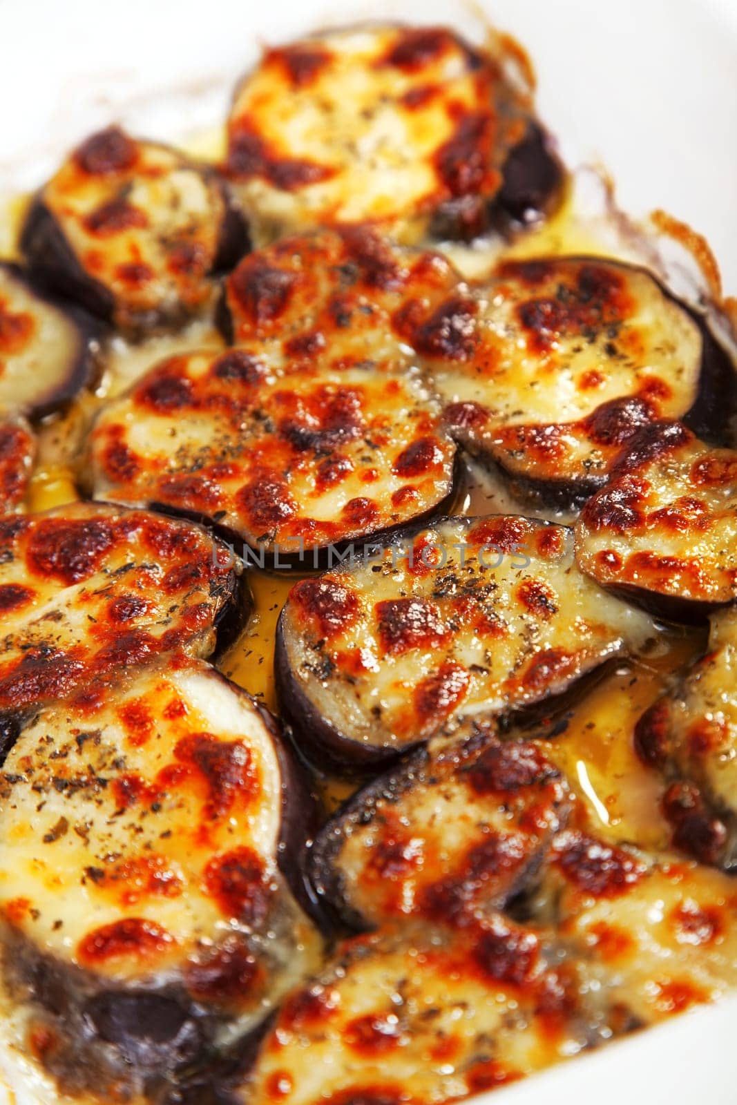 Baked eggplants with mozzarella and basil in a baking dish