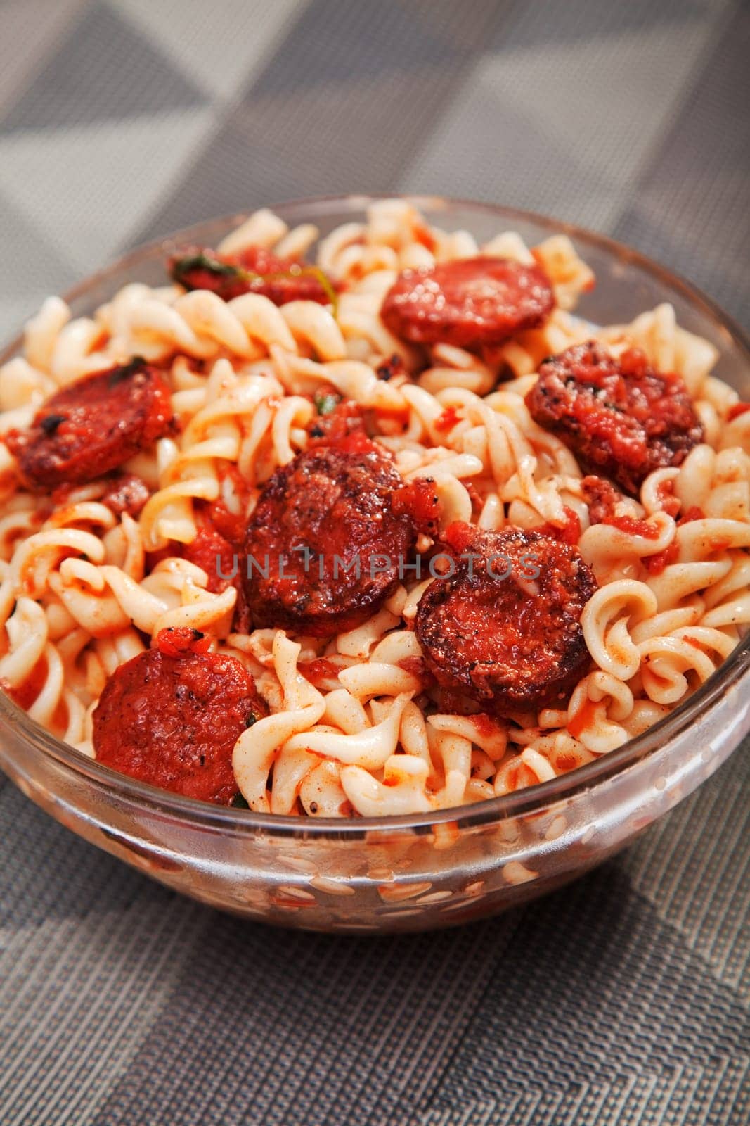 Italian dish - fusilli with sausage, tomato sauce and parmesan, close up