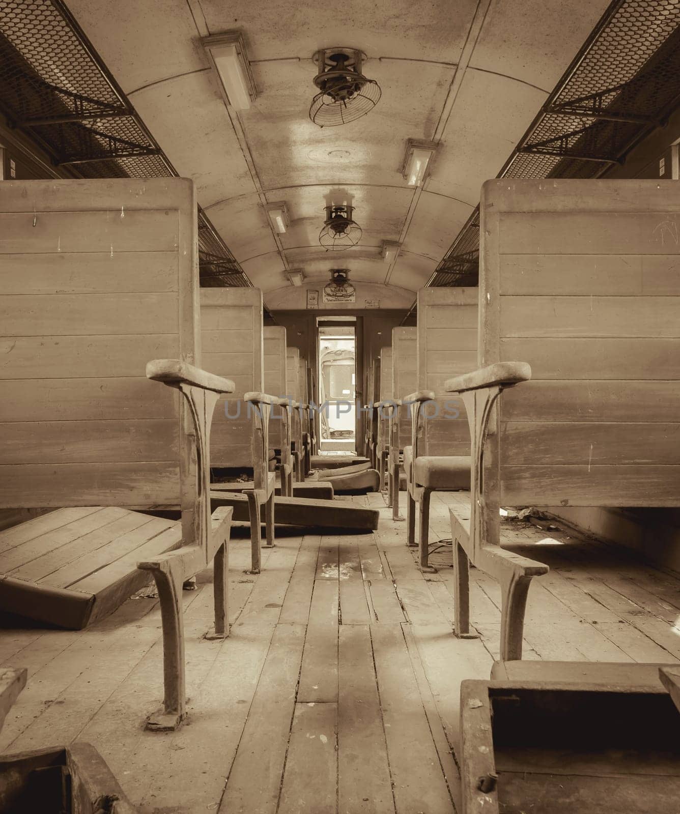 Interior of vintage abandoned passenger train with wooden seat