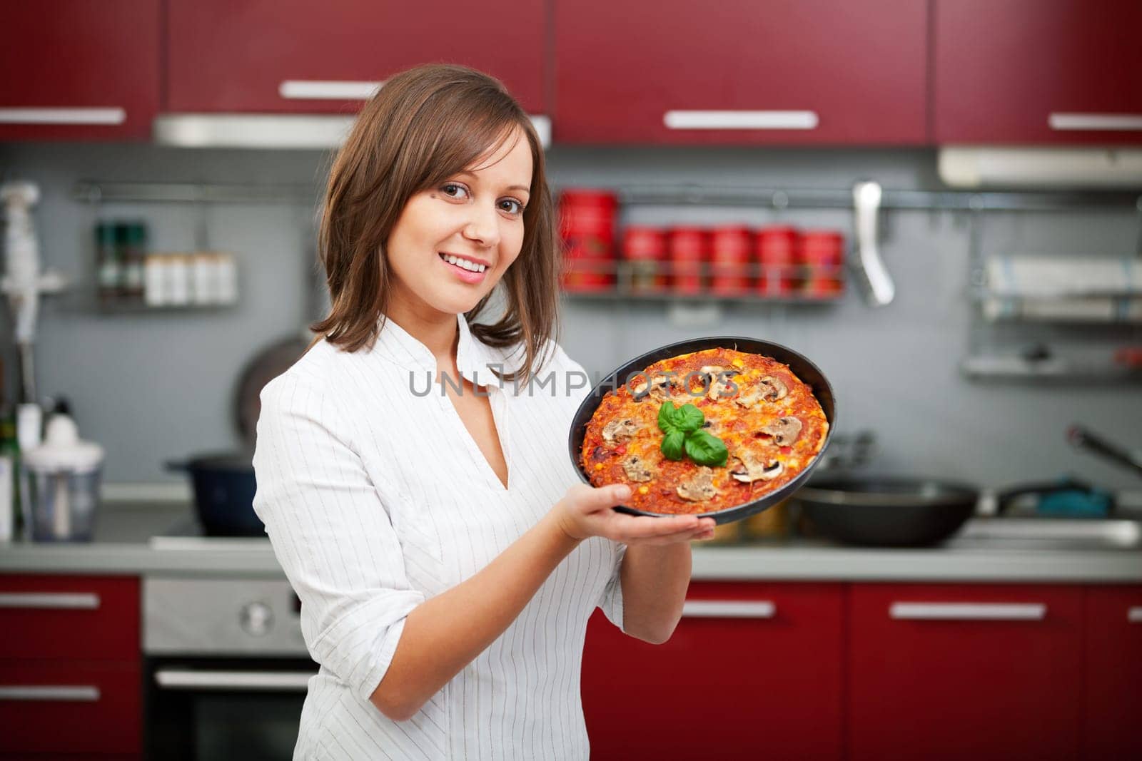 Young woman preparing homemade pizza - just after baking it