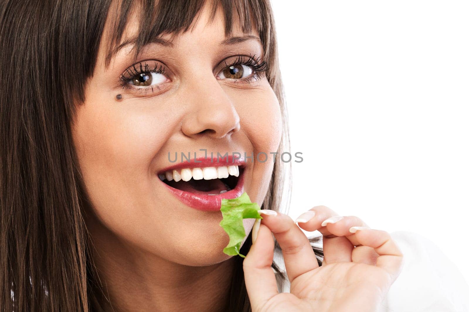 Young woman eating green salad, looking at camera, isolated on white background with copy space
