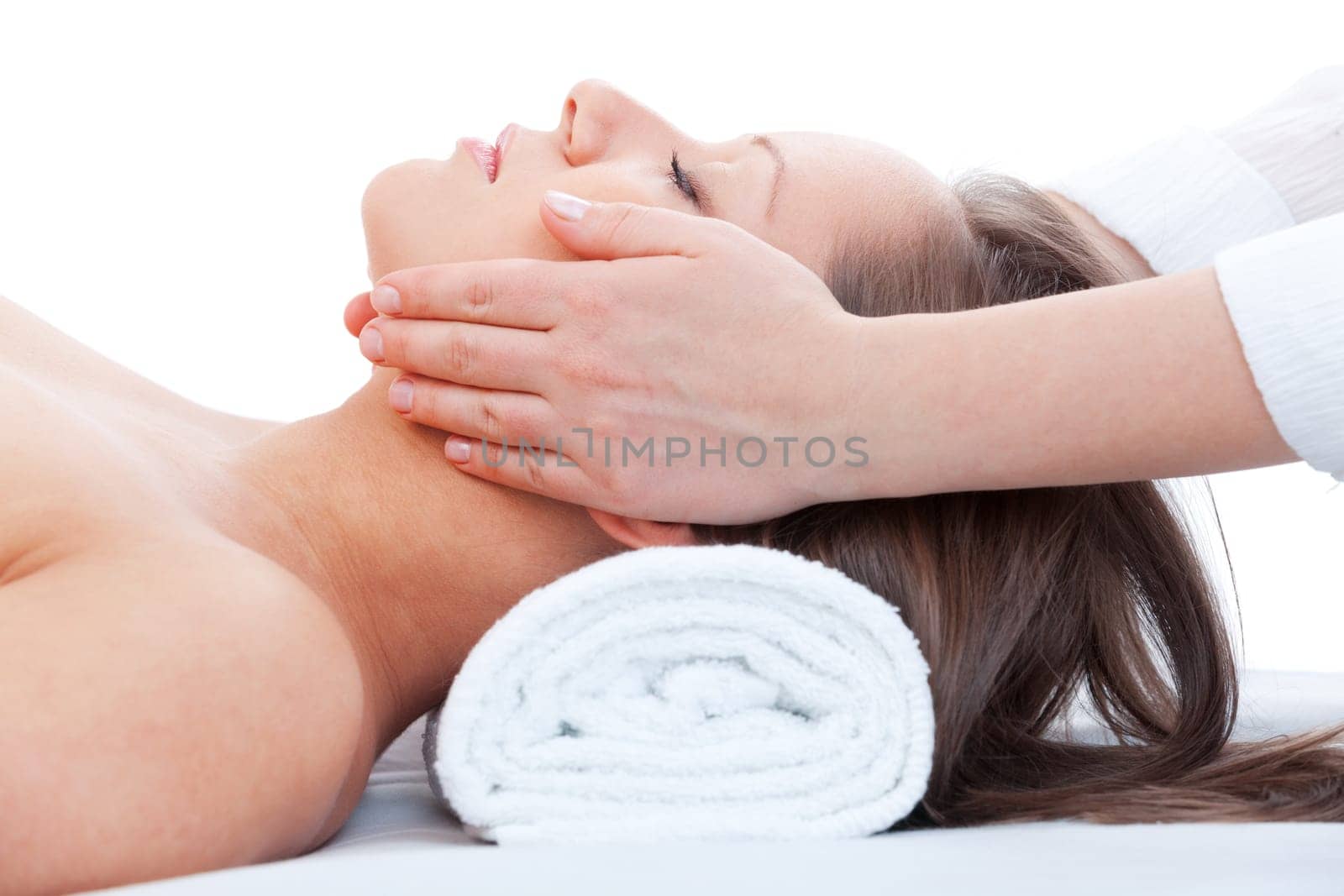 Young woman having a classical massage lying on white bed