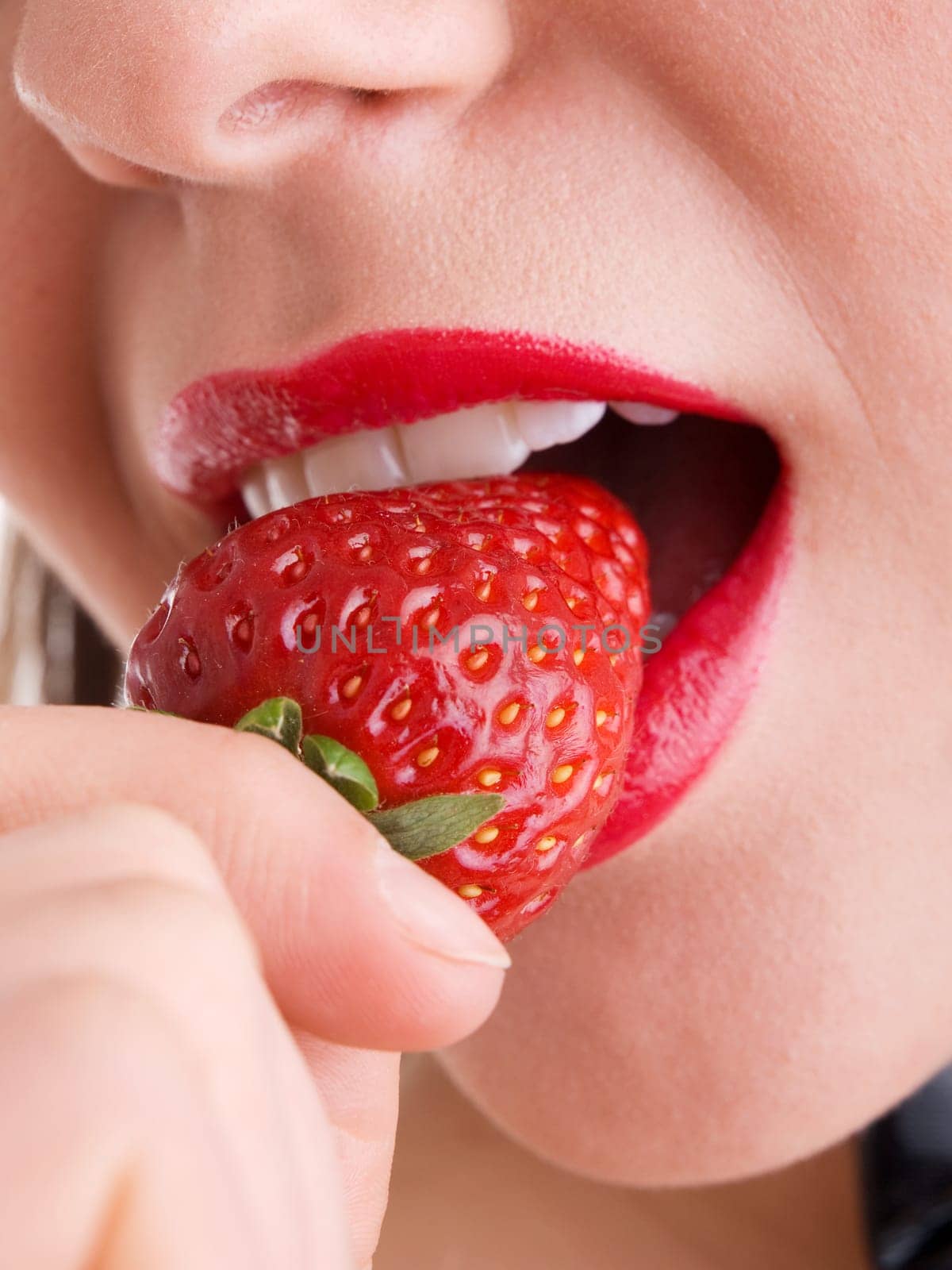 Young woman eating strawberry