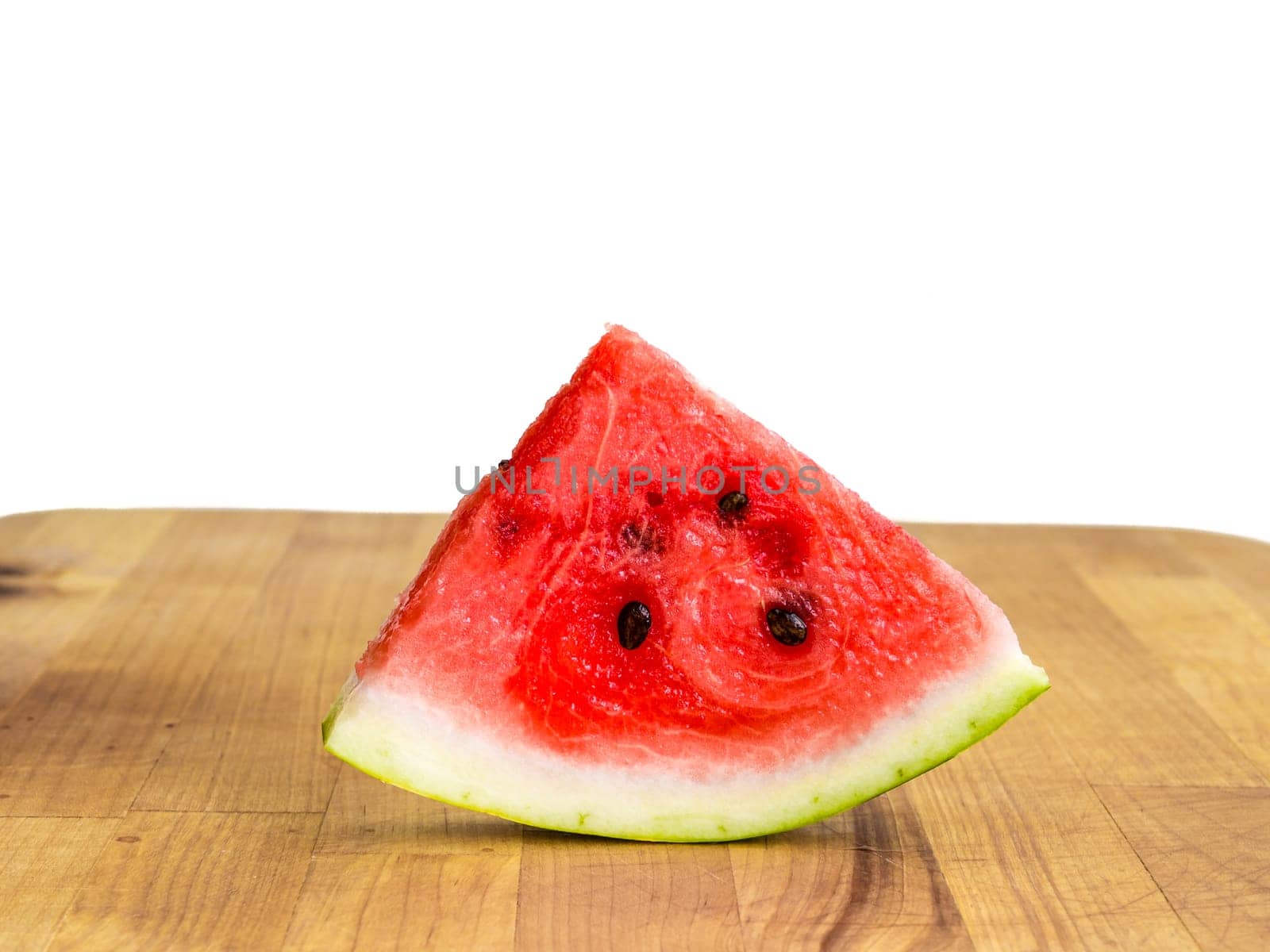 Watermelon slice arranged on a wooden board, raw food fruit stilllife with copyspace