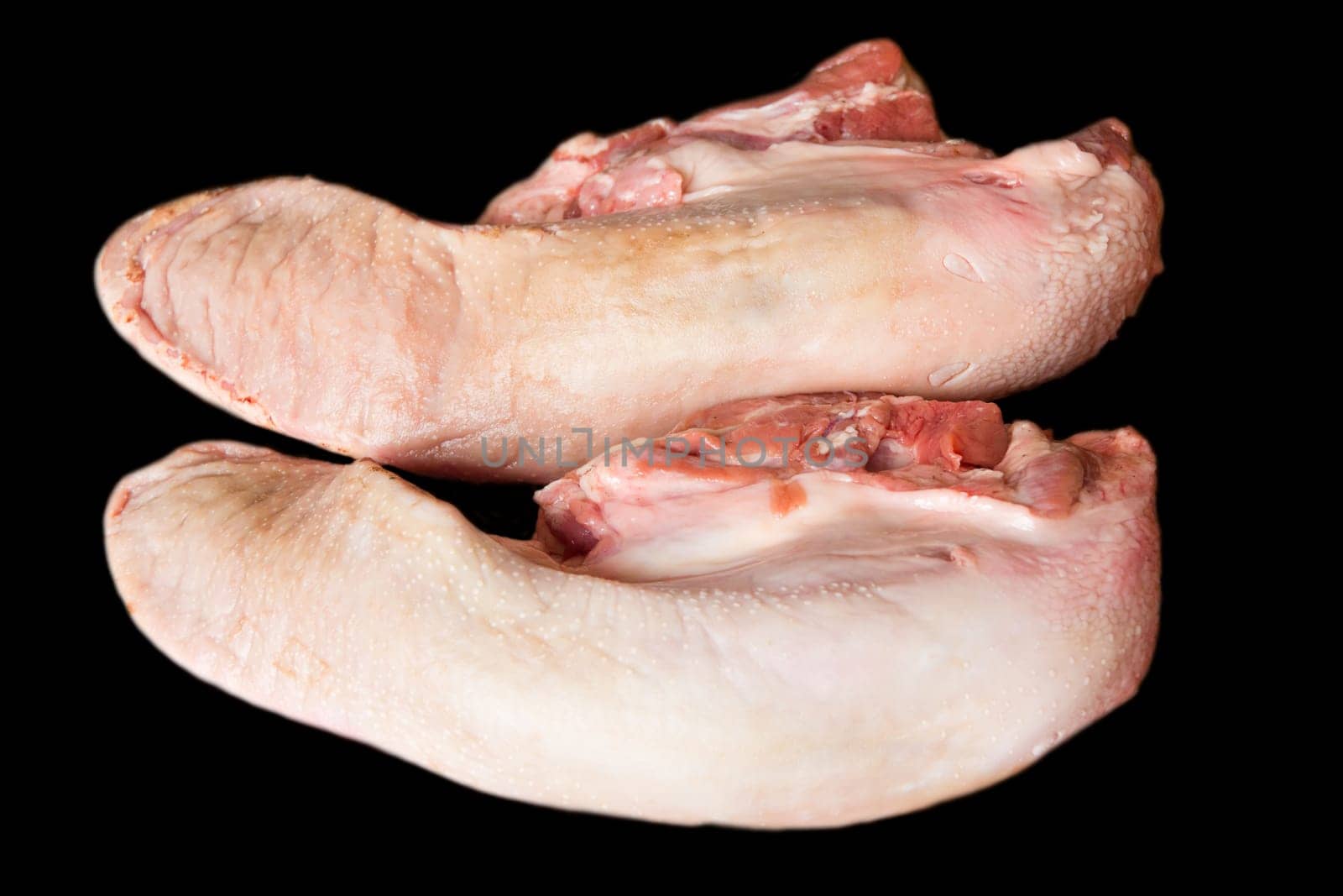 Photo of raw pork tongue on black background
