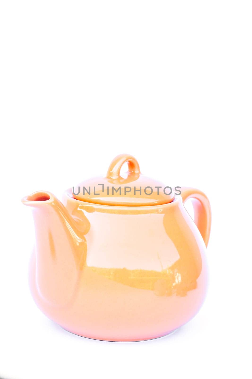 Orange ceramic teapot isolated on white background, stock photo
