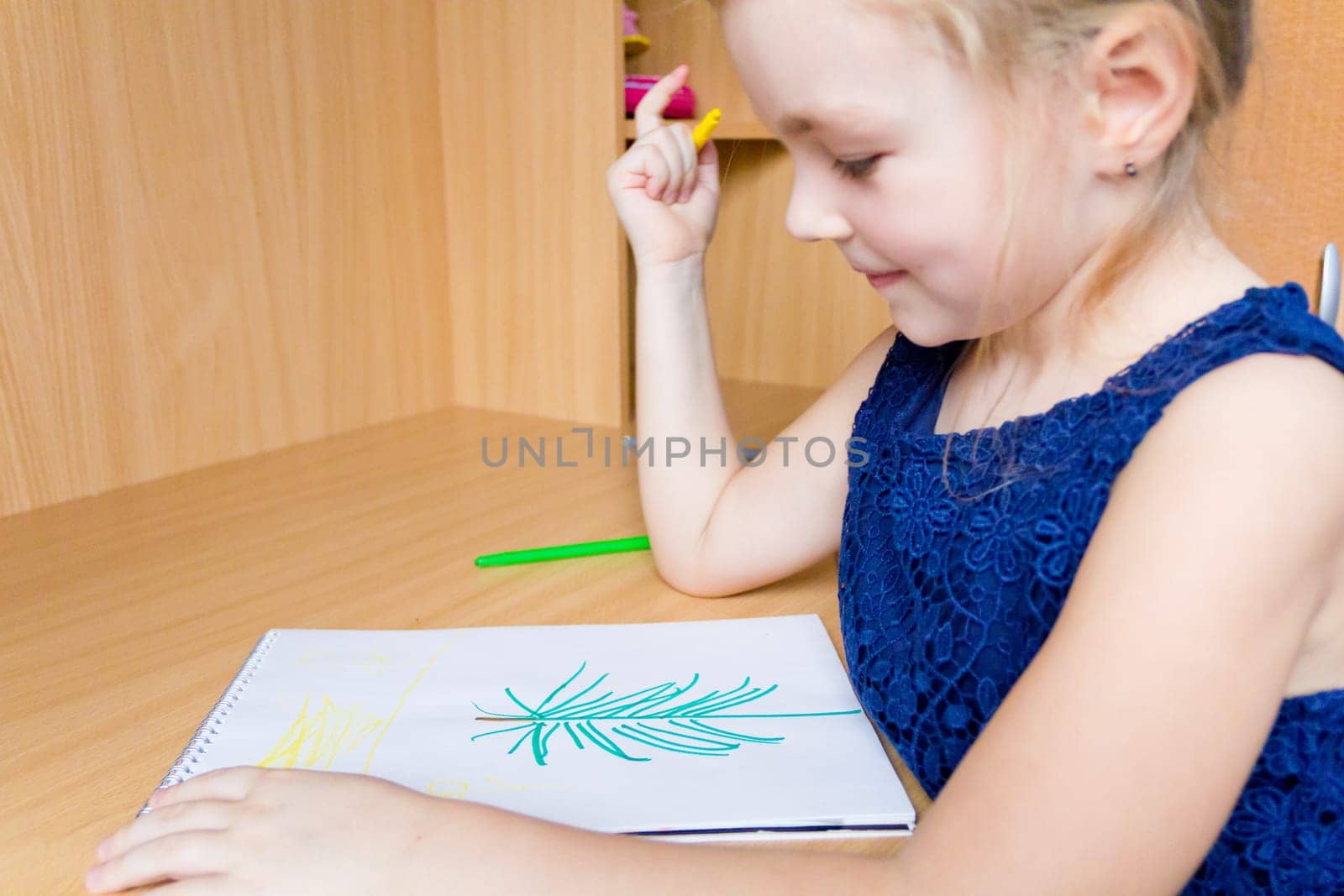 Photo of cute drawing girl with blond hair