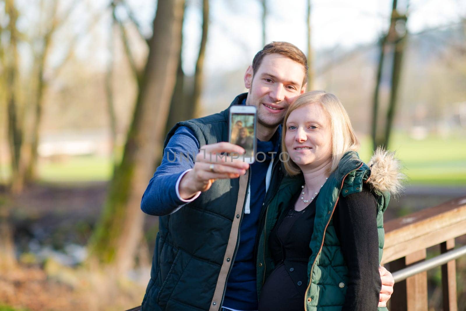 young pregnant woman with her husband in the park