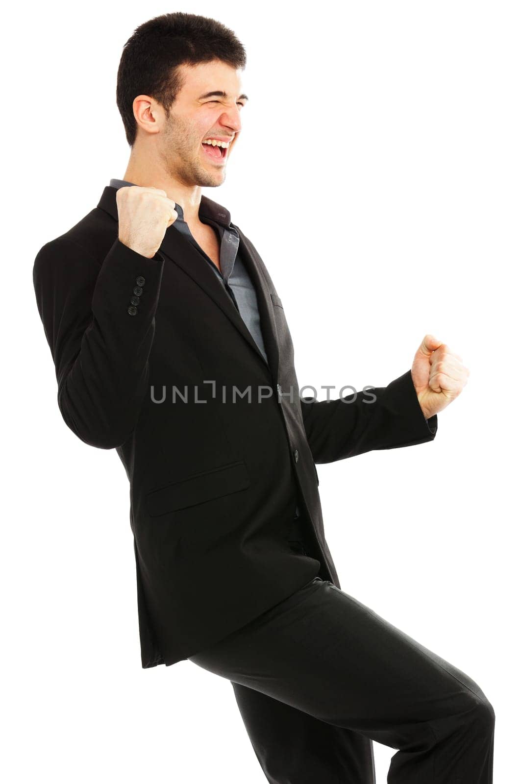 Young businessman punching the air from joy. Isolated on white background