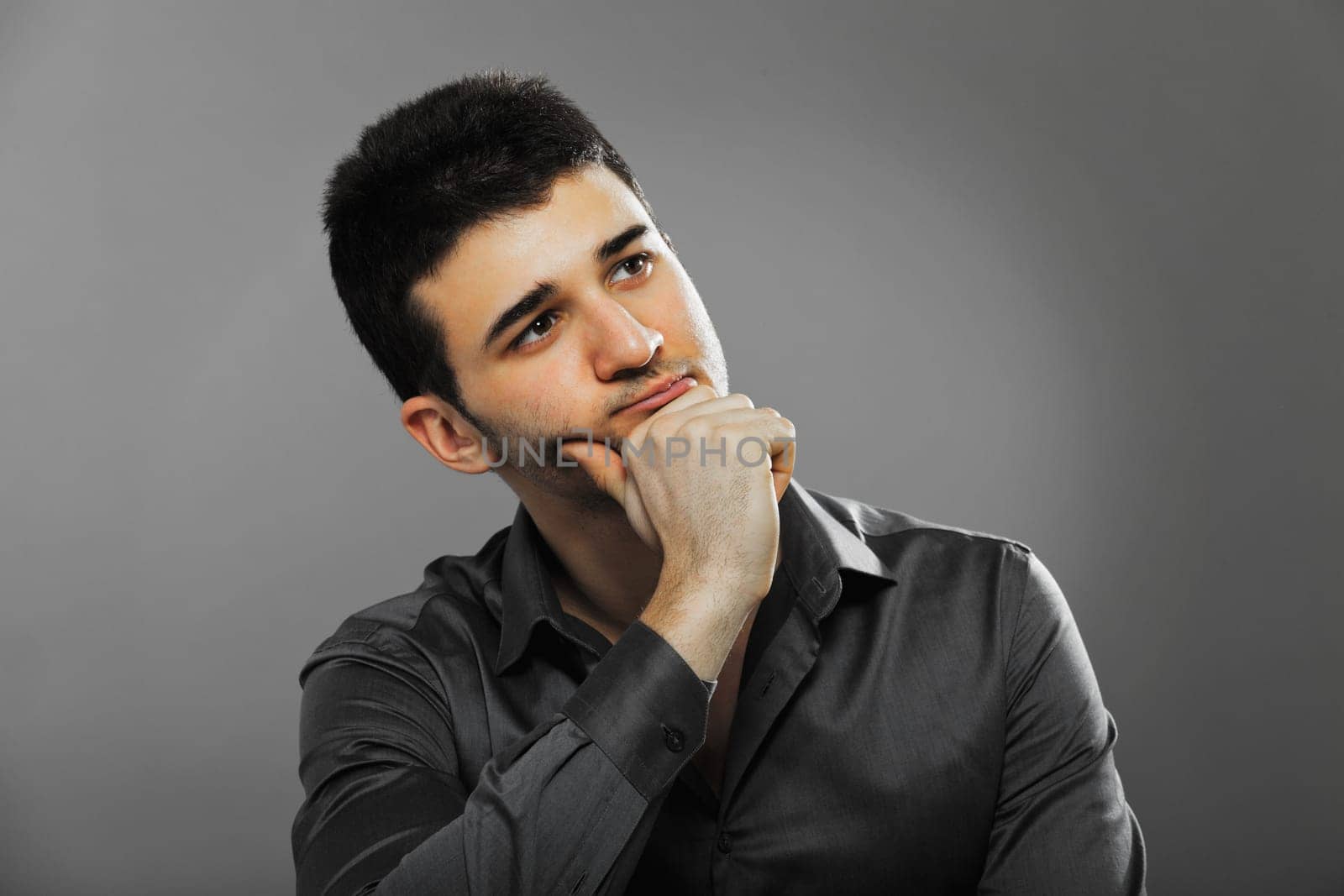 Young businessman portrait isolated on gray background.