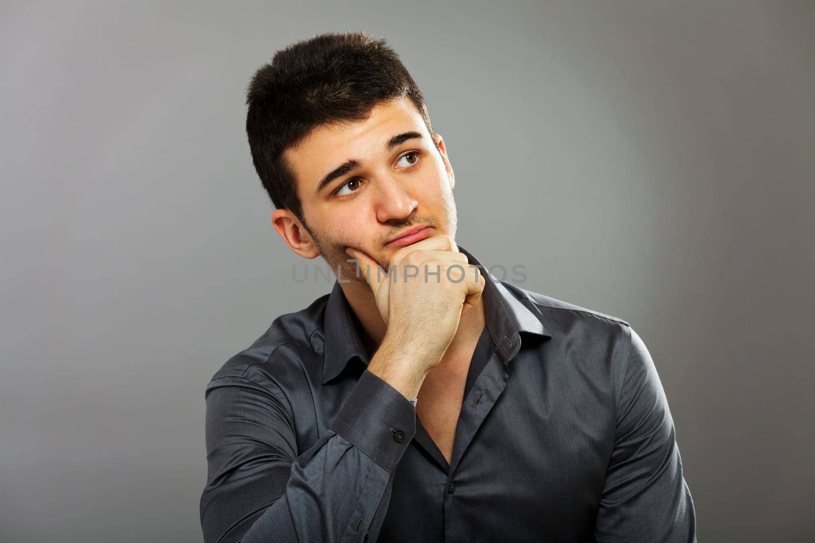 Young businessman portrait isolated on gray, horizontal shot