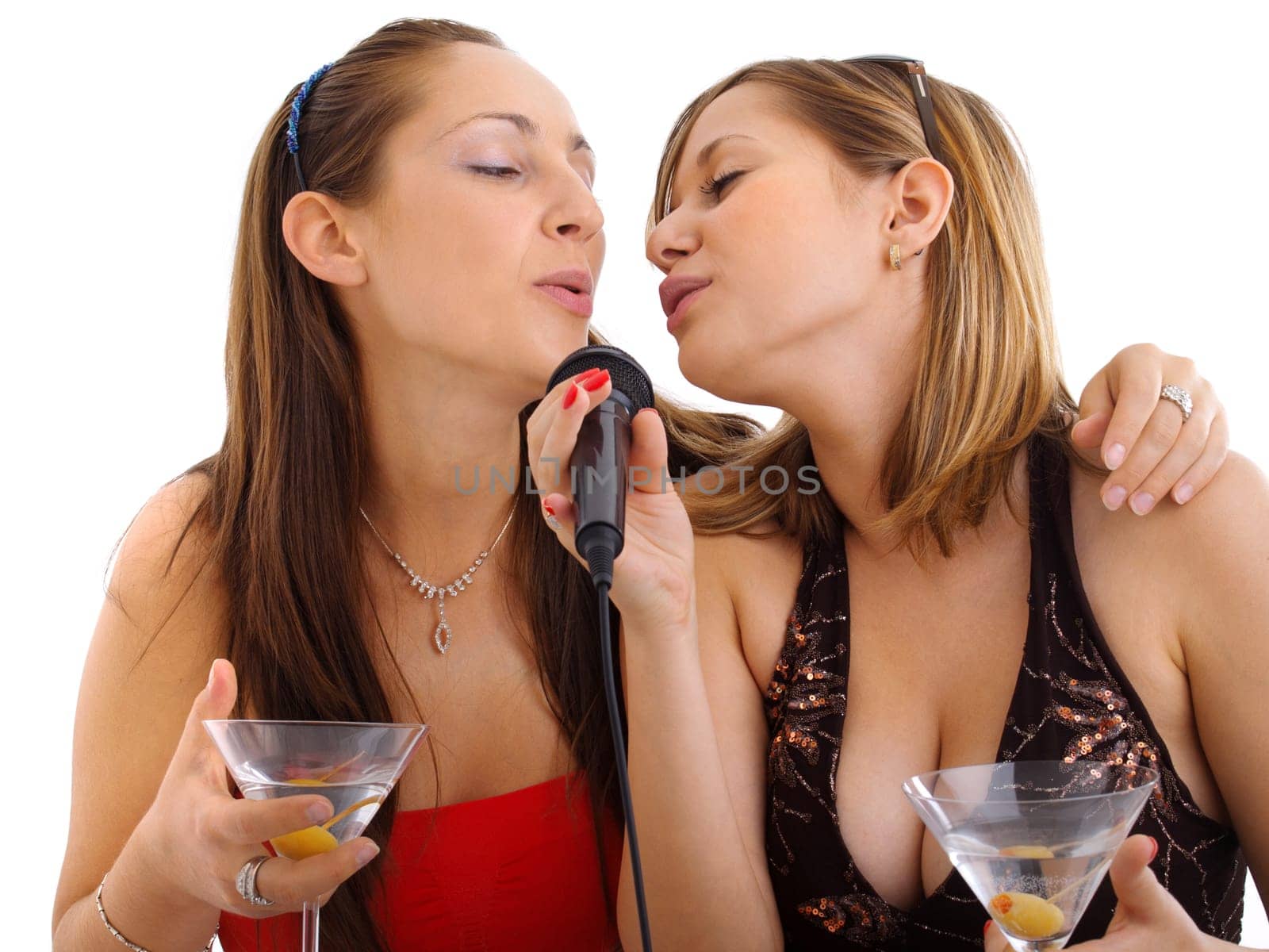 Girls singing with a microphone, drinking martini cocktail, isolated on white