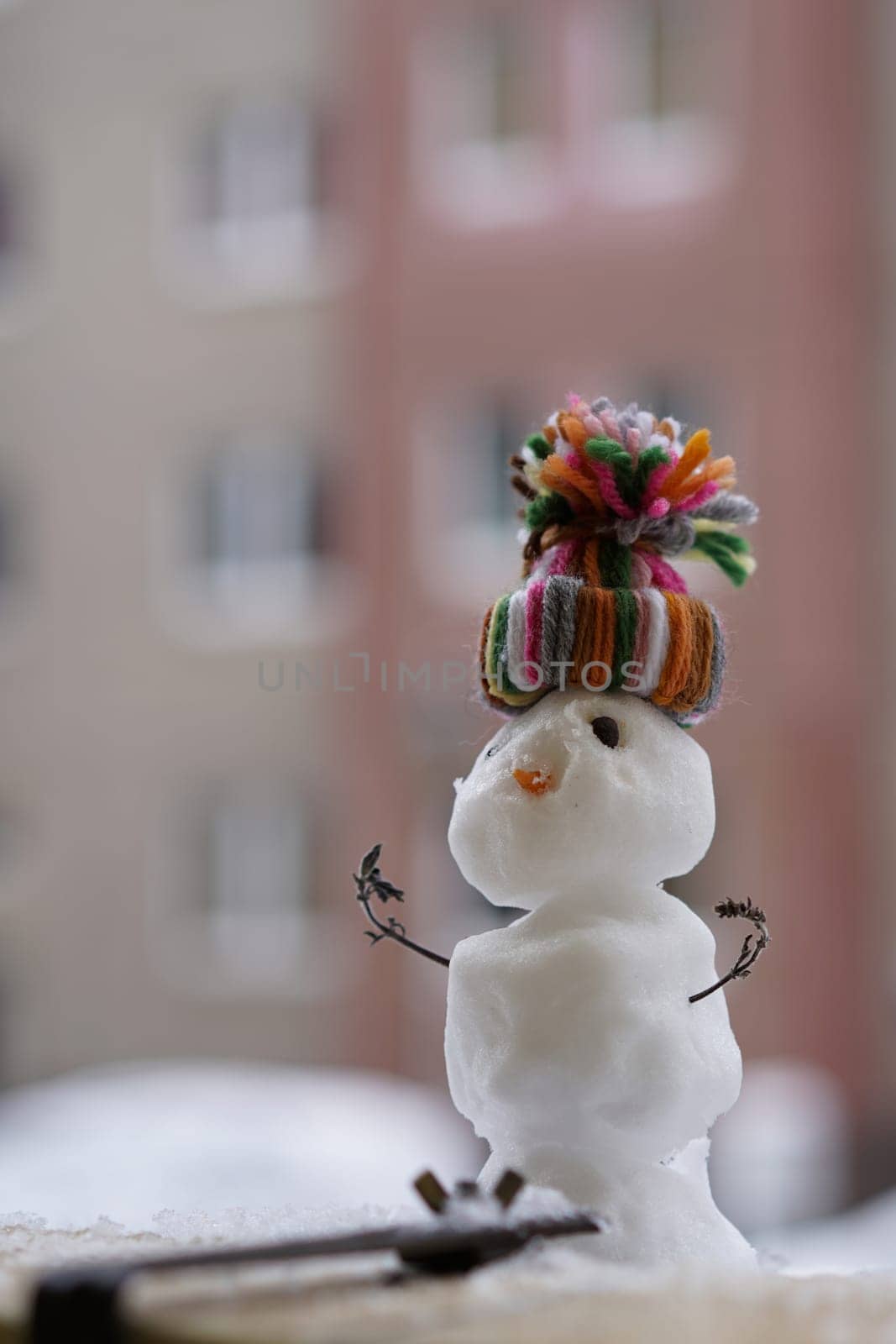 Snowman in winter on a balcony parapet