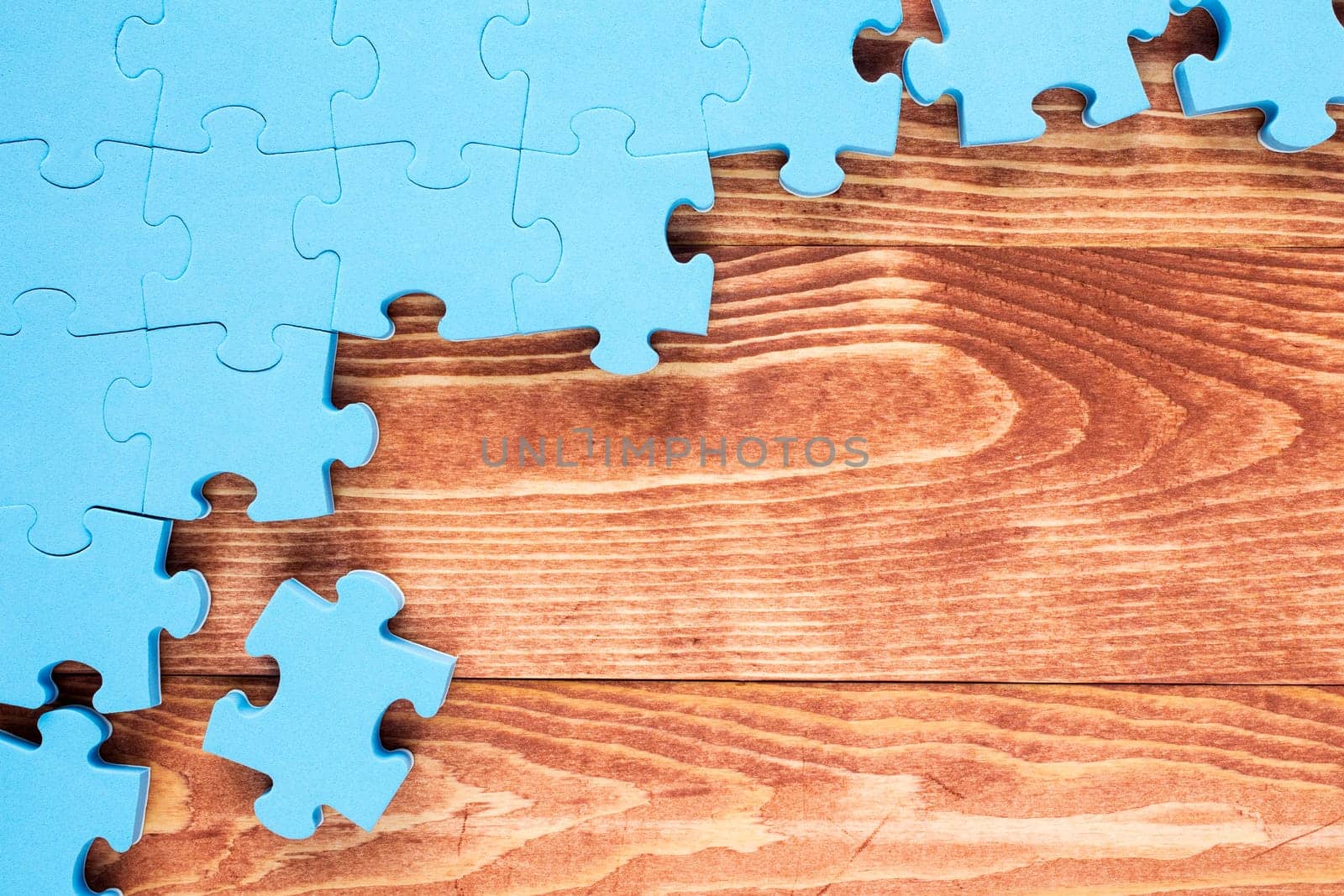 Puzzle on brown wooden background.Team business concept