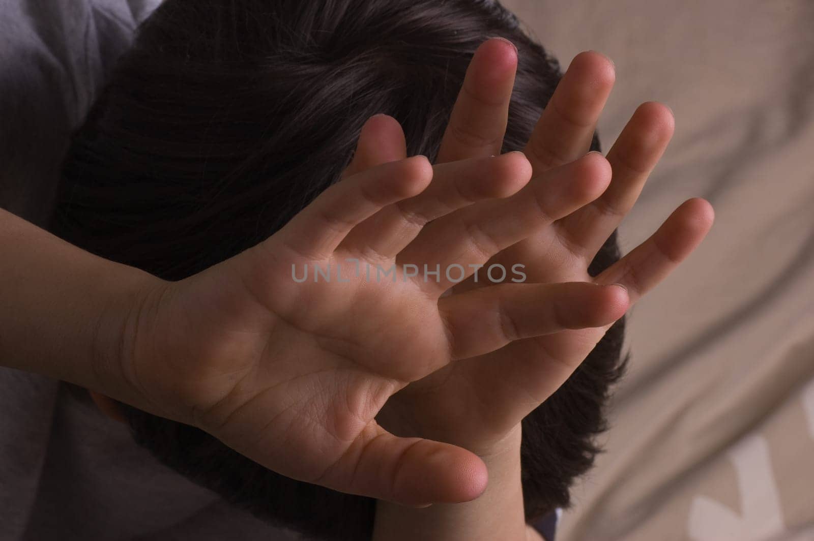 Child raising hands to protect itself
