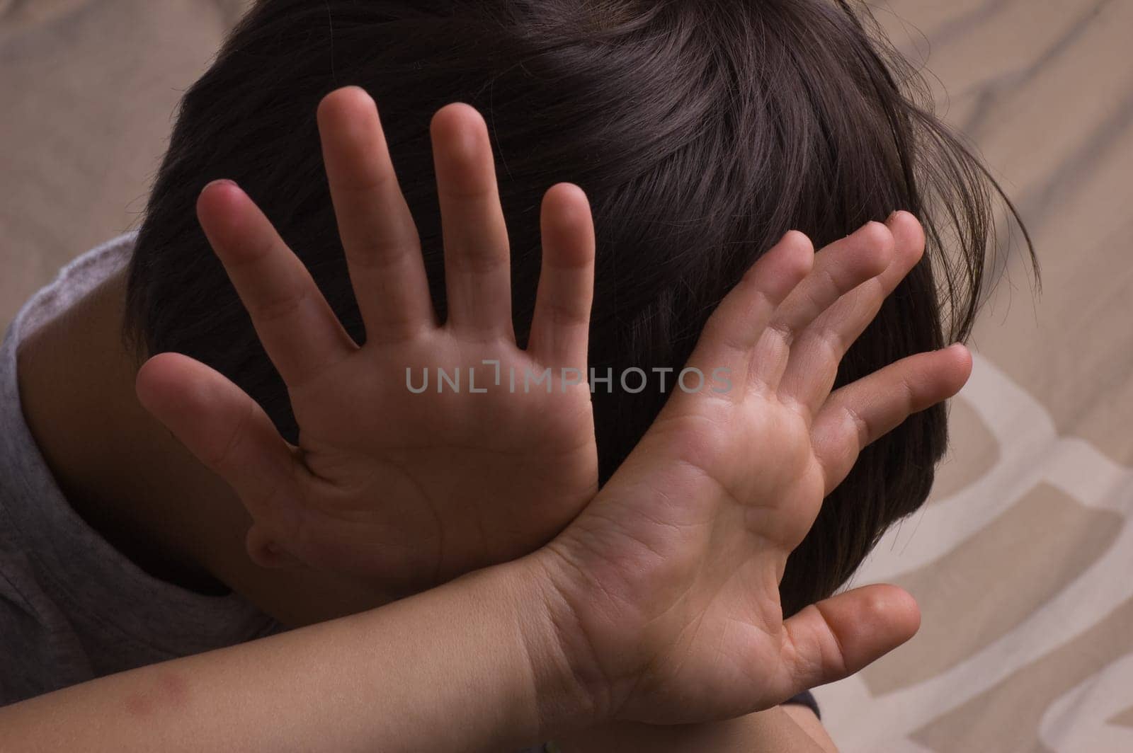 Child raising hands to protect itself
